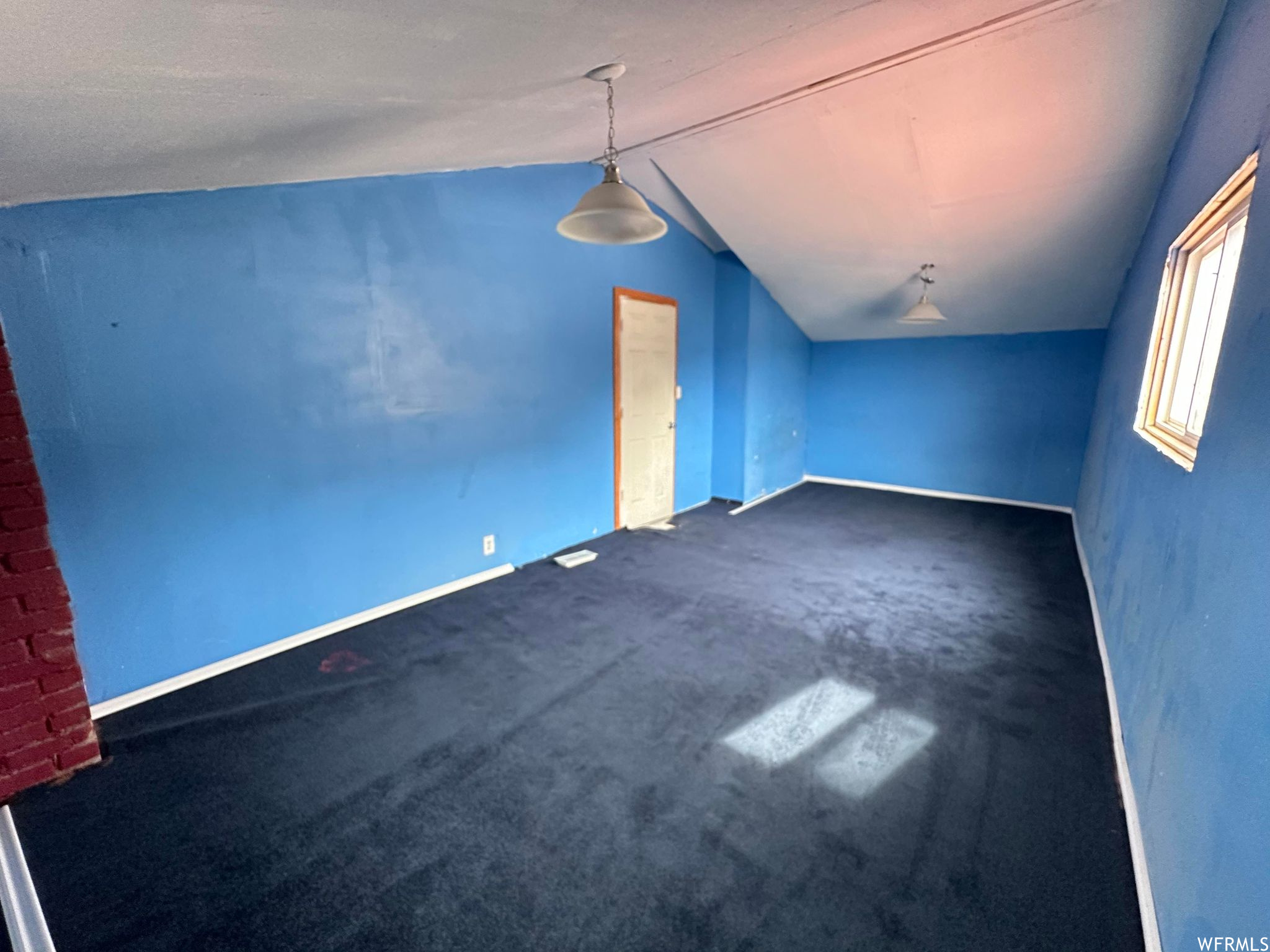 Bonus room featuring dark carpet and vaulted ceiling