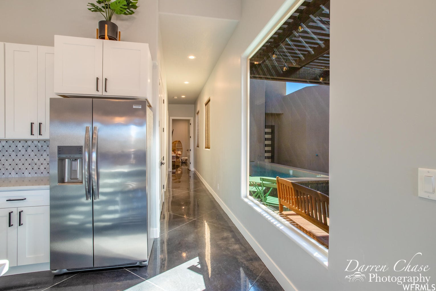 Kitchen featuring refrigerator, white cabinets, and dark floors