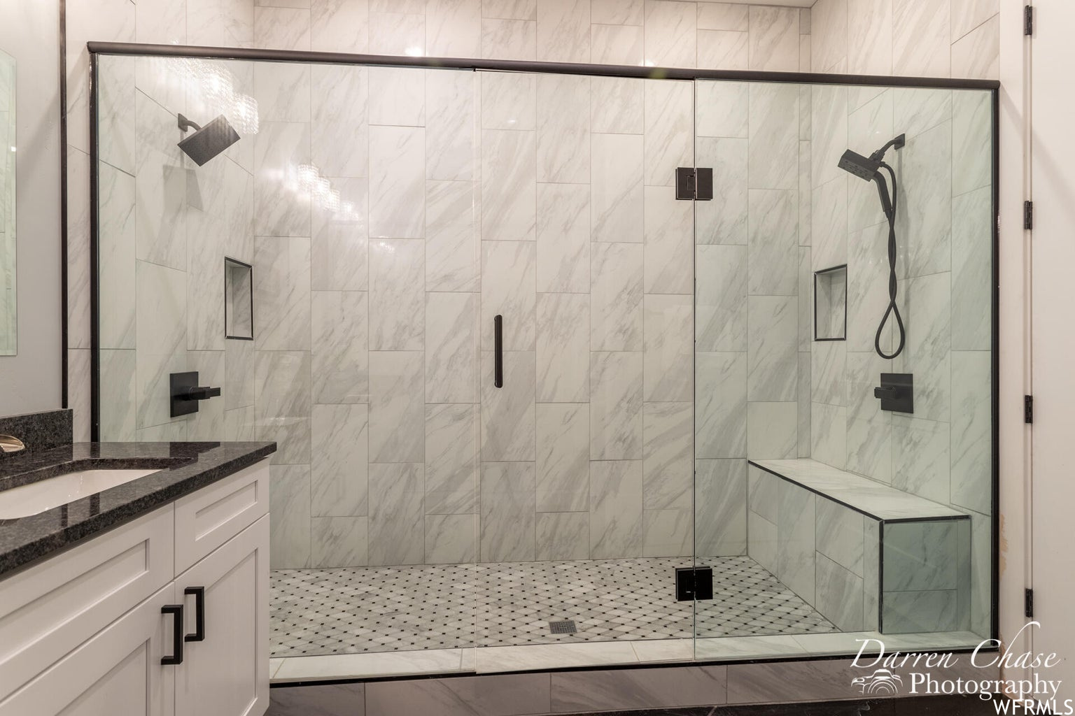 Bathroom featuring tile floors, enclosed shower, and vanity