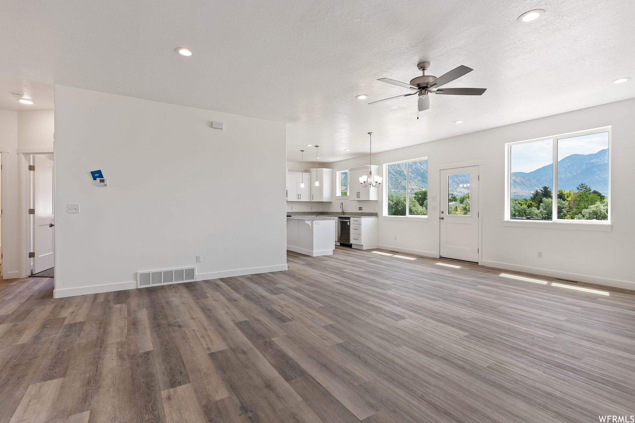 Living room featuring ceiling fan and light hardwood floors