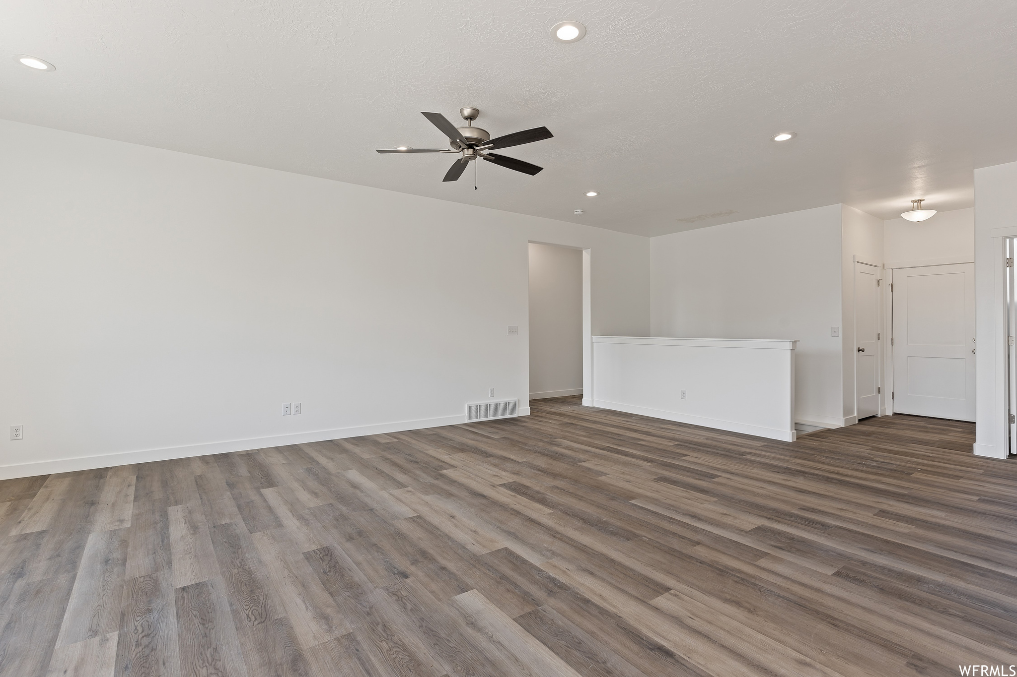 Unfurnished room featuring ceiling fan and light hardwood flooring