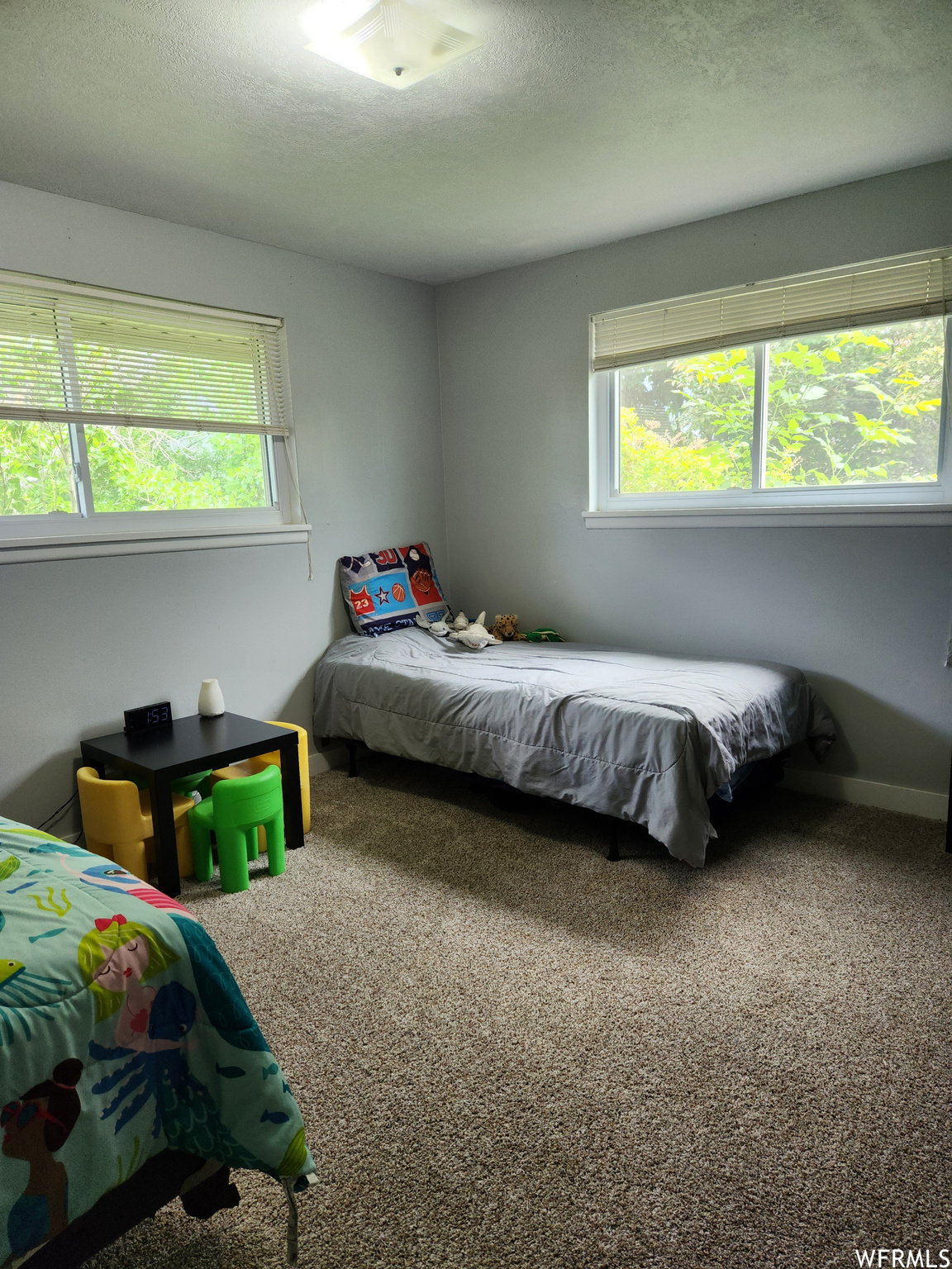 Bedroom with a textured ceiling and carpet