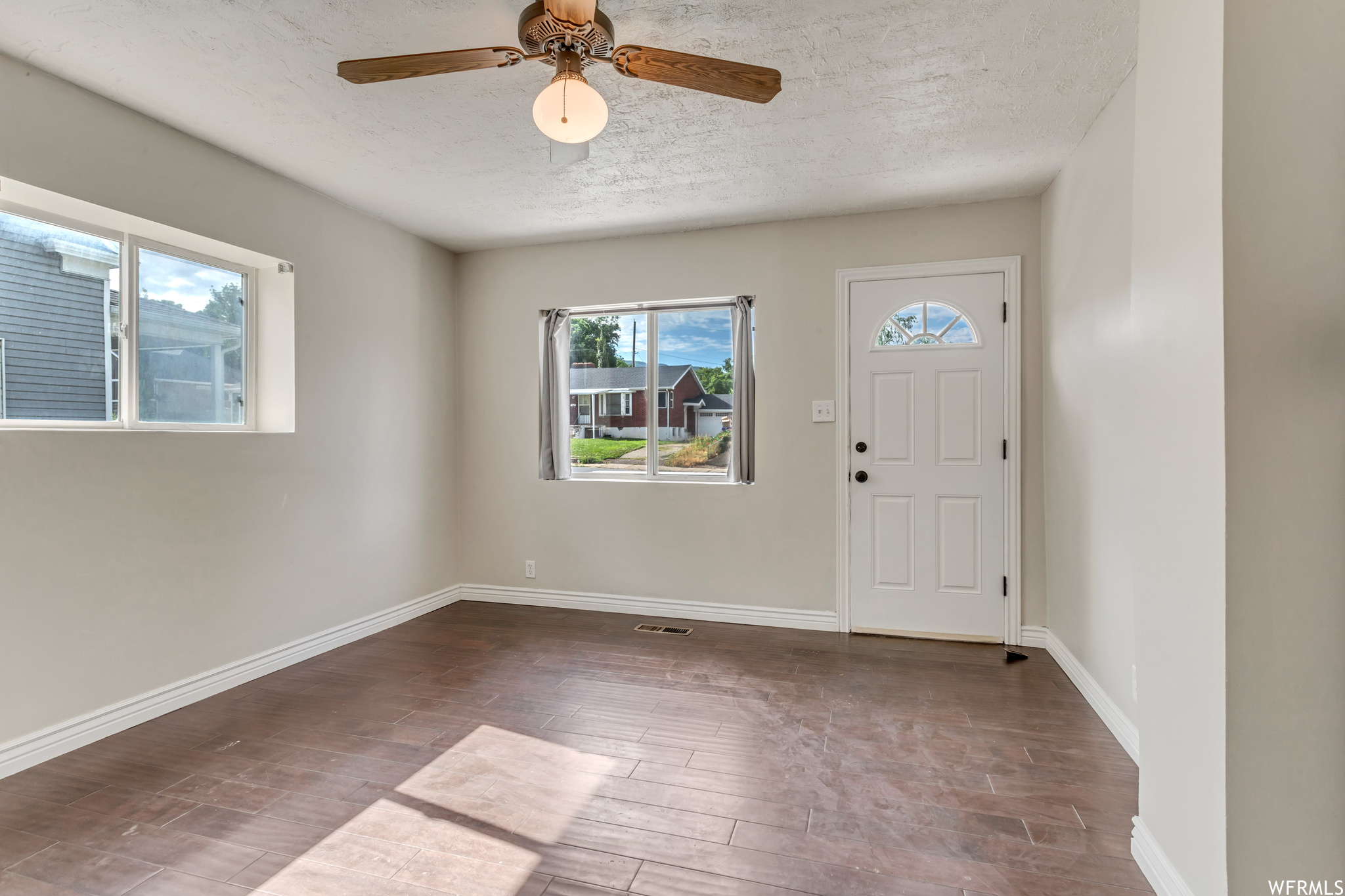 Foyer featuring ceiling fan and hardwood floors