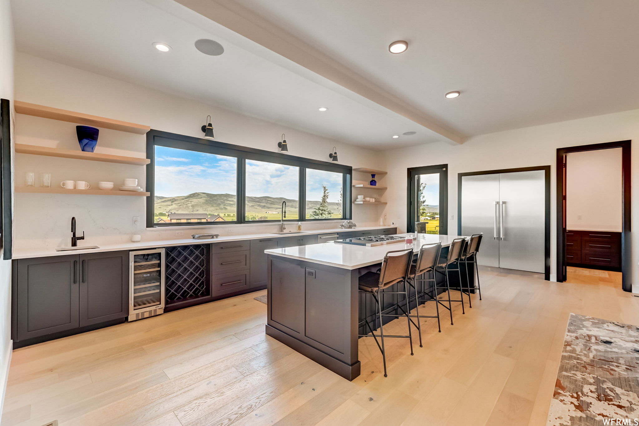 Kitchen with light hardwood / wood-style flooring, a wealth of natural light, and wine cooler