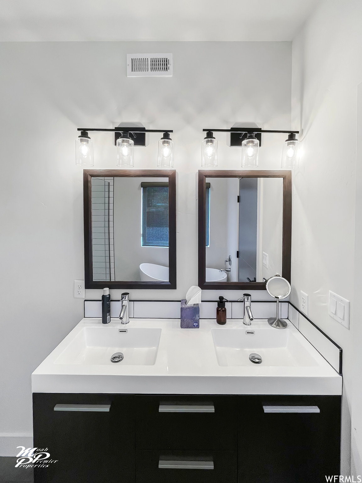 Bathroom featuring dual vanity and mirror