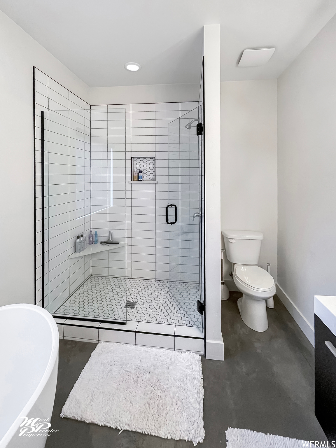 Full bathroom with concrete floors, vanity, and separate shower and tub enclosures