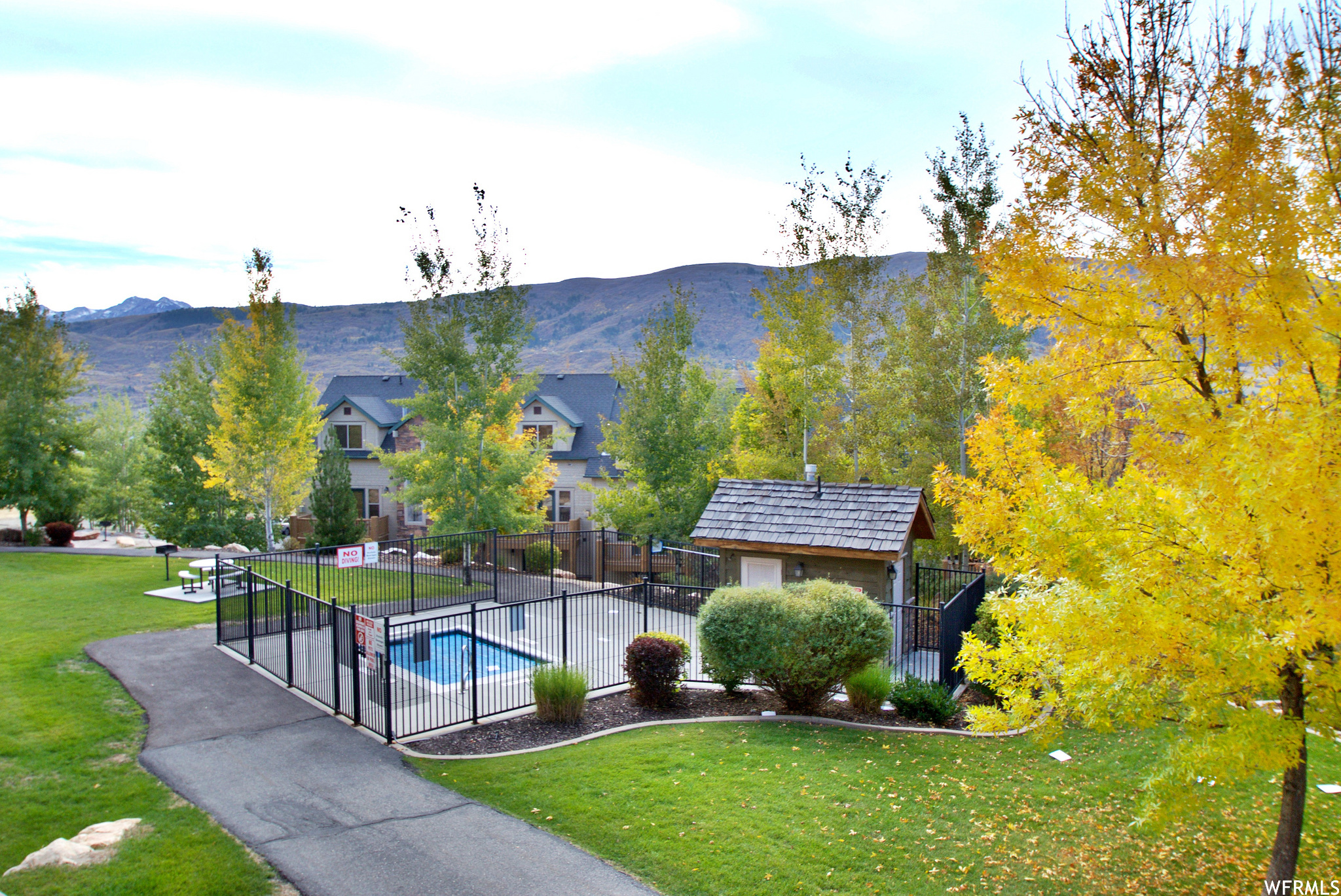 View of home's community featuring an outdoor structure, a lawn, and a mountain view