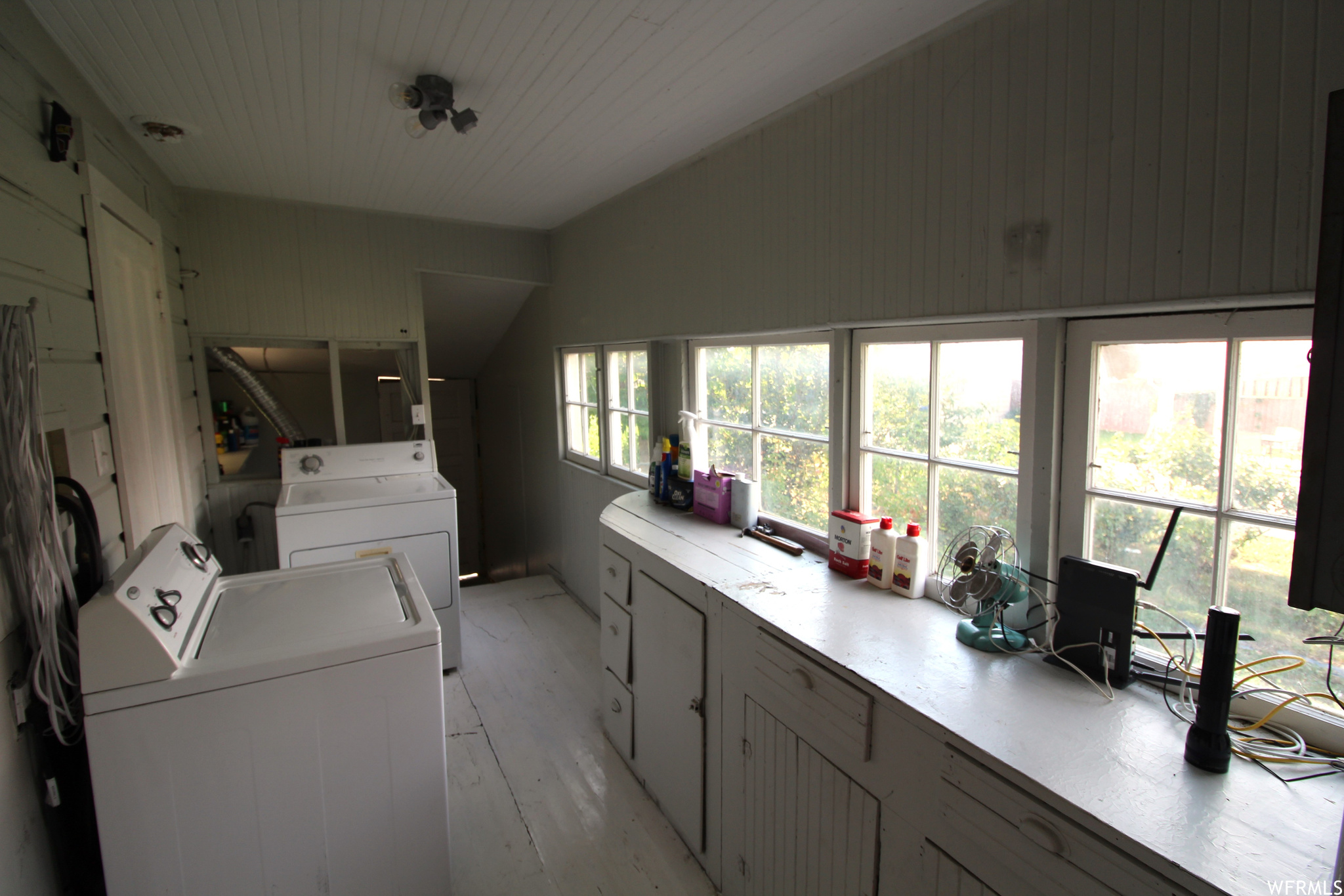 View of main utility area from kitchen door.  Great counterspace and original cabinetry for tons of auxiliary kitchen storage and workspace.  Windows look out into the side / rose garden.