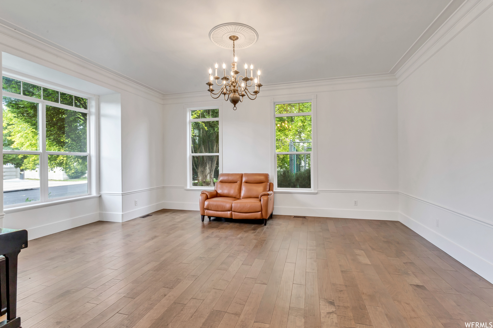 Living area featuring crown molding and light hardwood floors