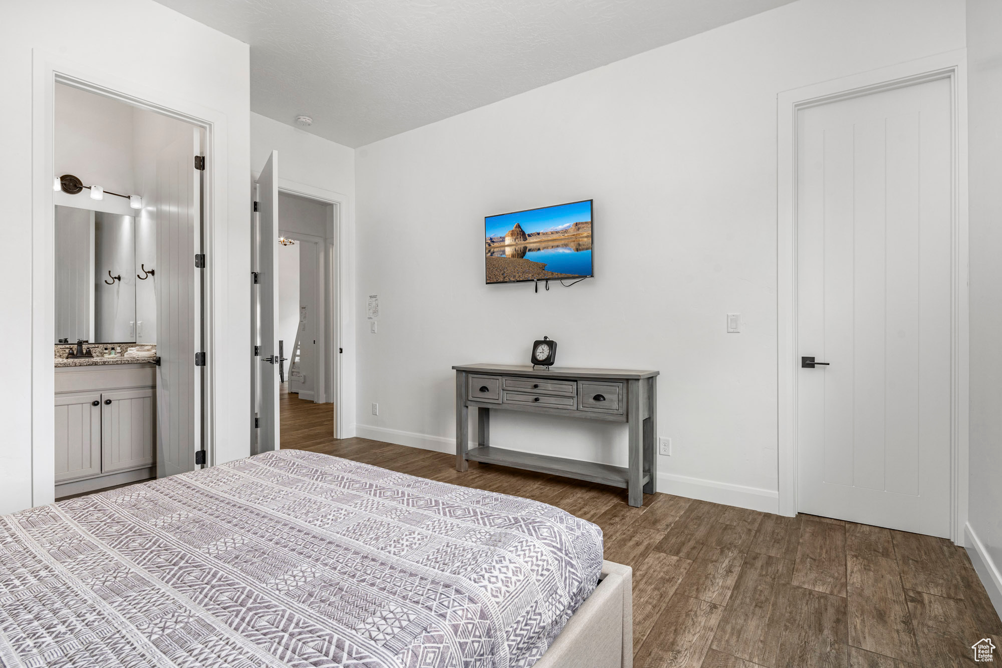 Bedroom featuring dark wood-type flooring, sink, and connected bathroom