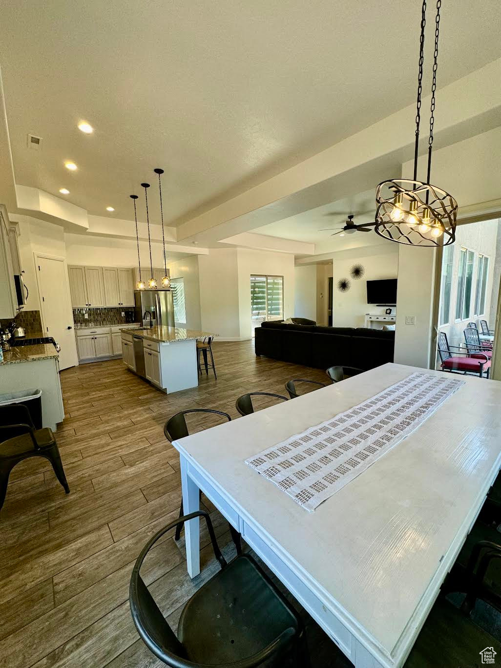 Dining space with ceiling fan, wood-type flooring, and a raised ceiling