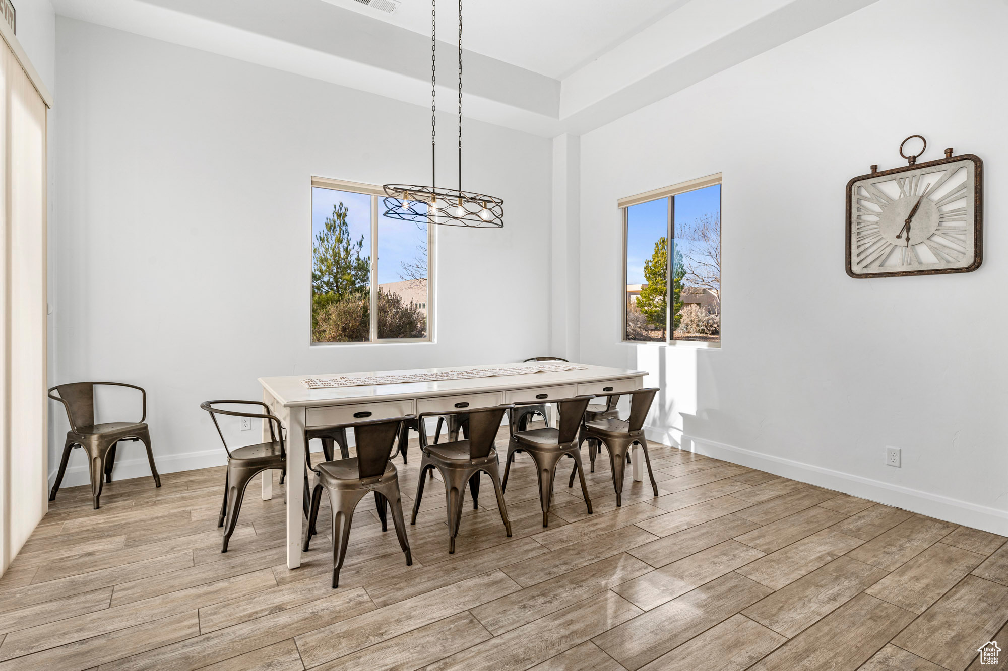Dining space with light hardwood / wood-style floors and a notable chandelier