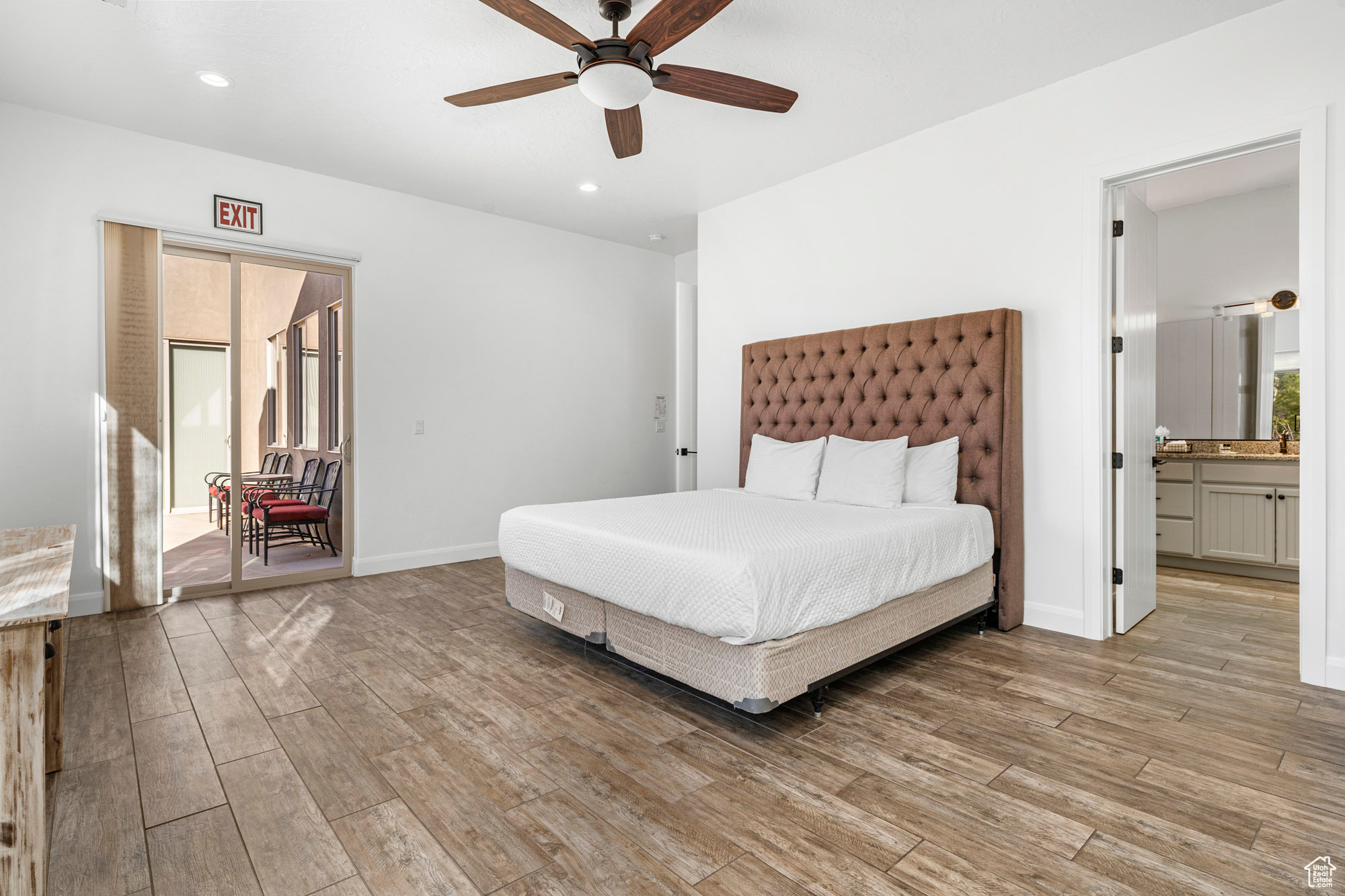 Bedroom featuring ensuite bathroom, light hardwood / wood-style flooring, and ceiling fan