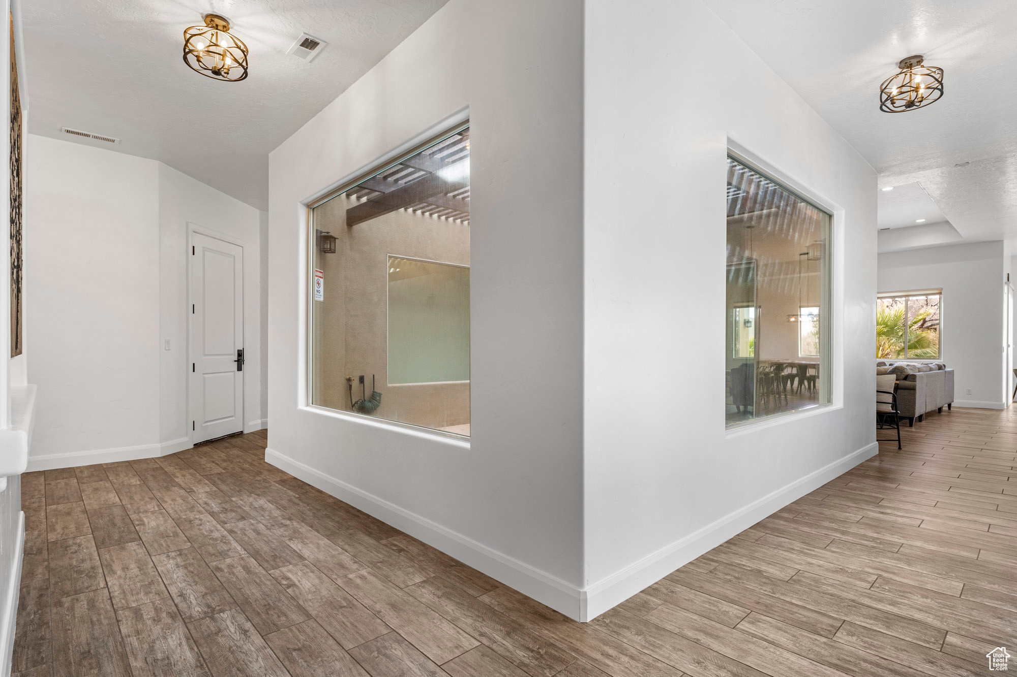 Hallway featuring a notable chandelier and light wood-type flooring