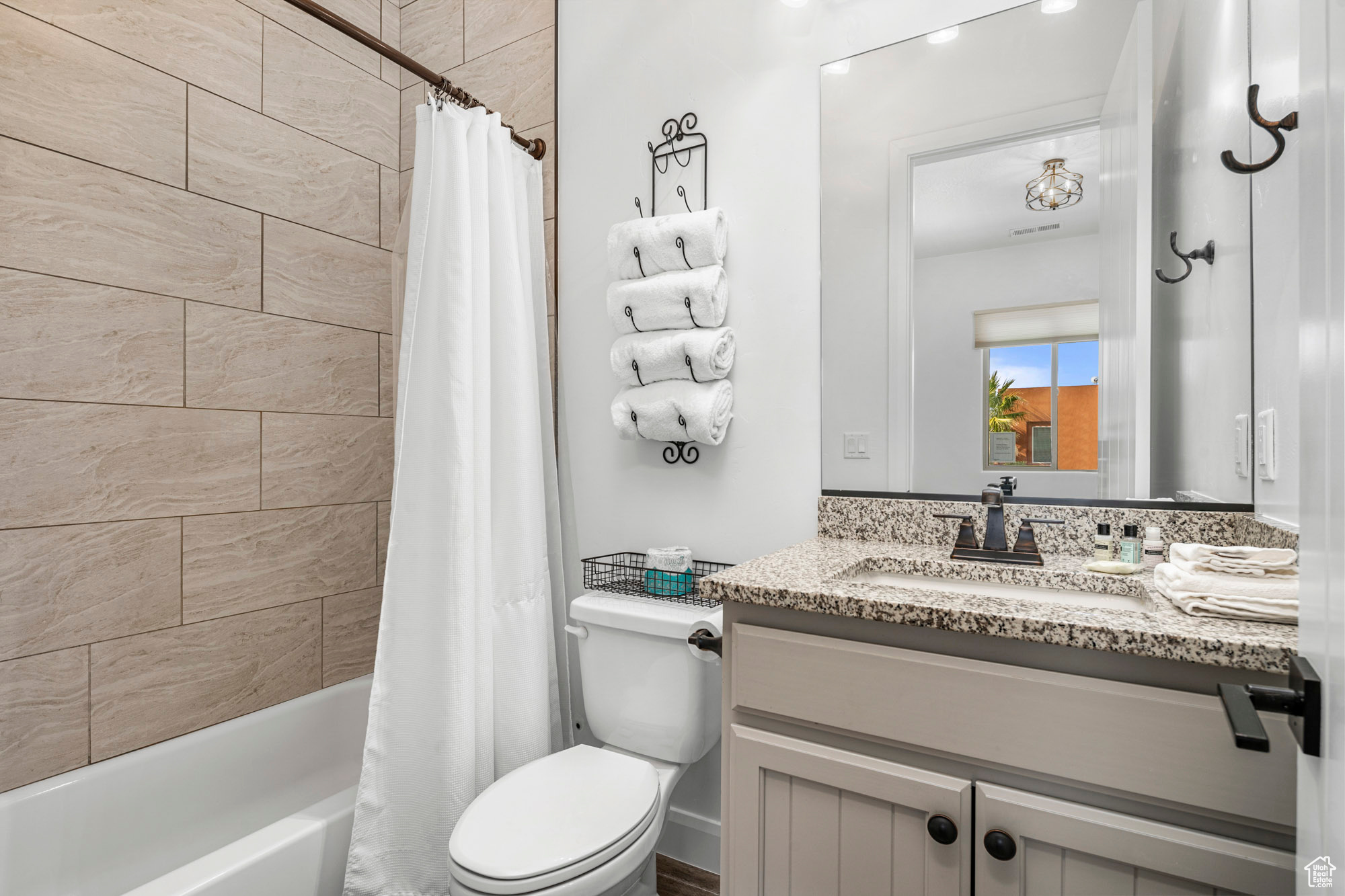 Full bathroom with vanity, shower / tub combo with curtain, and toilet