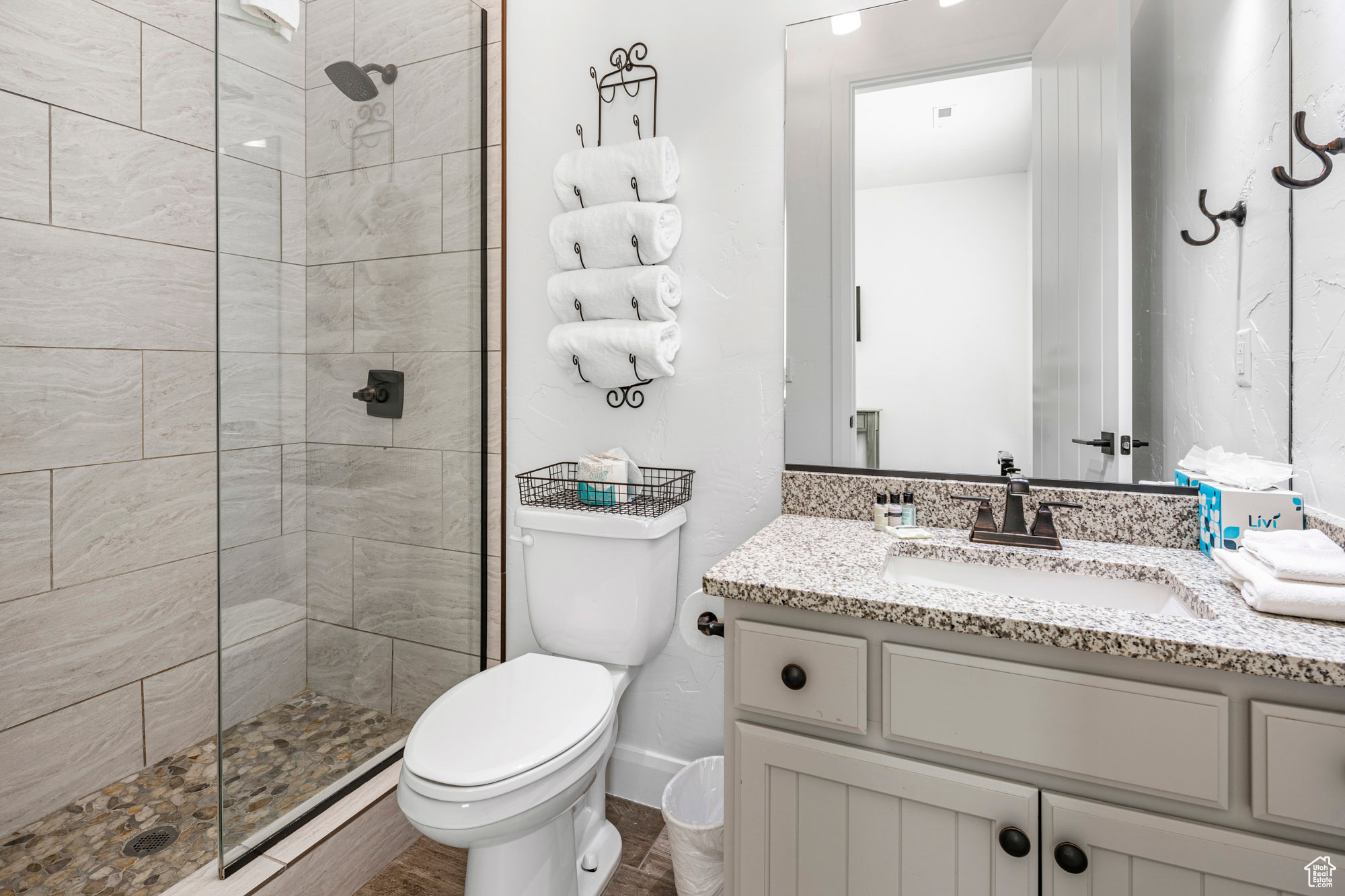 Bathroom featuring a tile shower, toilet, and oversized vanity