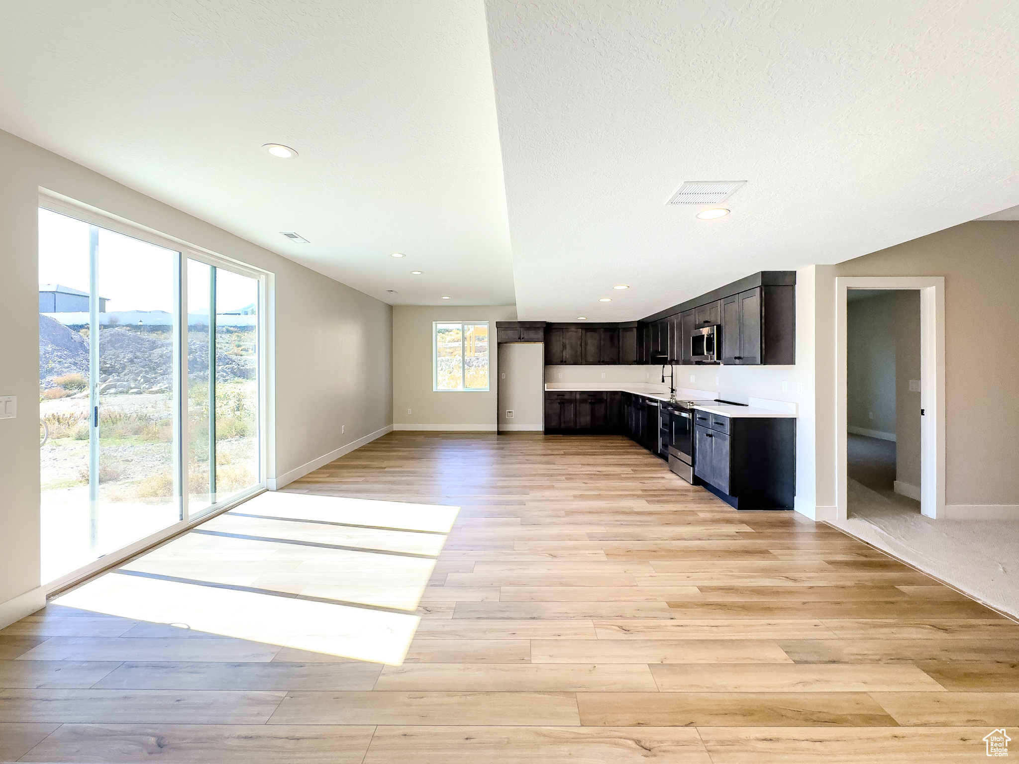 Kitchen with light wood-type flooring, a textured ceiling, sink, and a mountain view