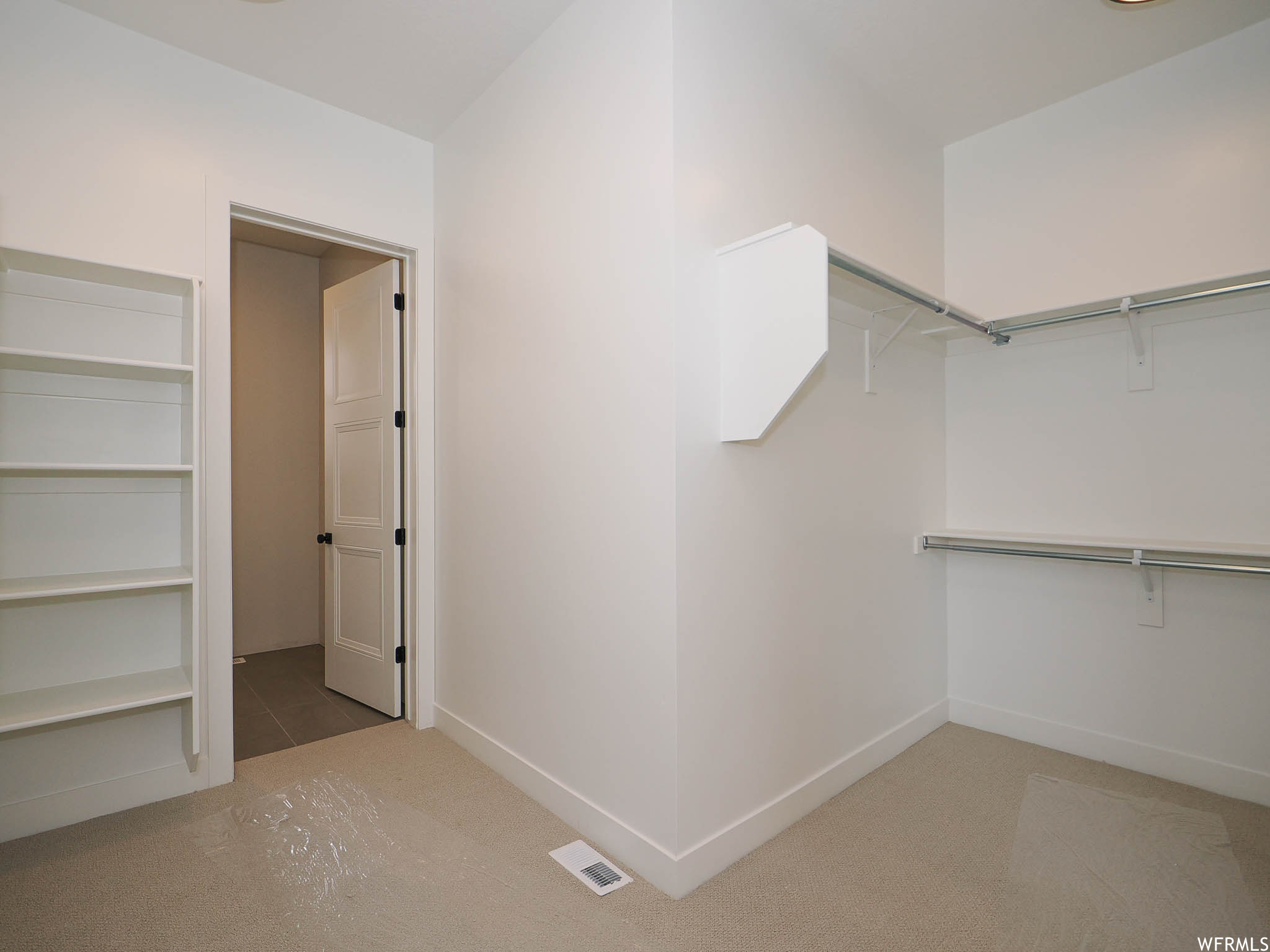 Walk in closet with light tile floors