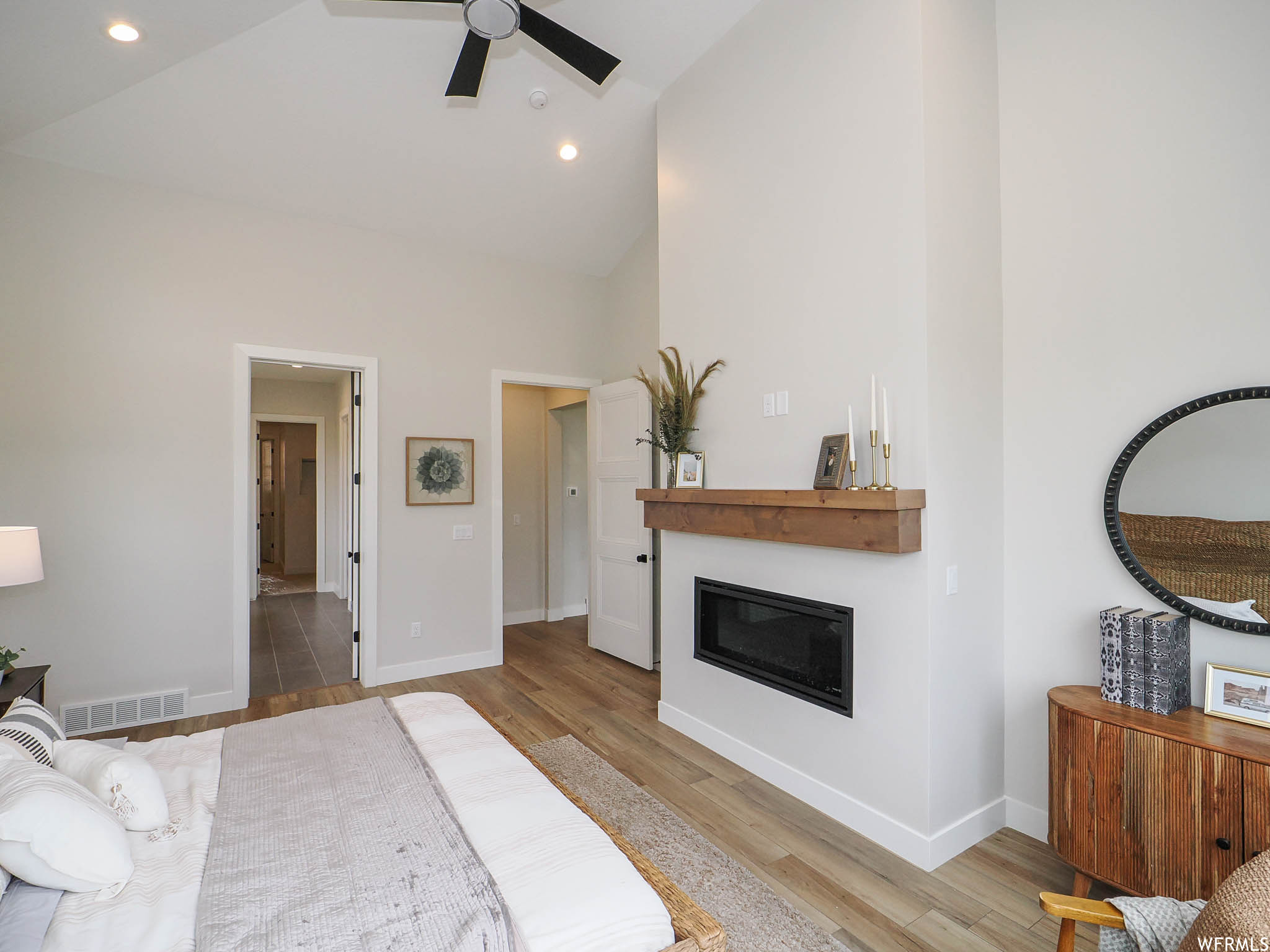 Bedroom featuring a high ceiling, lofted ceiling, ceiling fan, and light tile floors