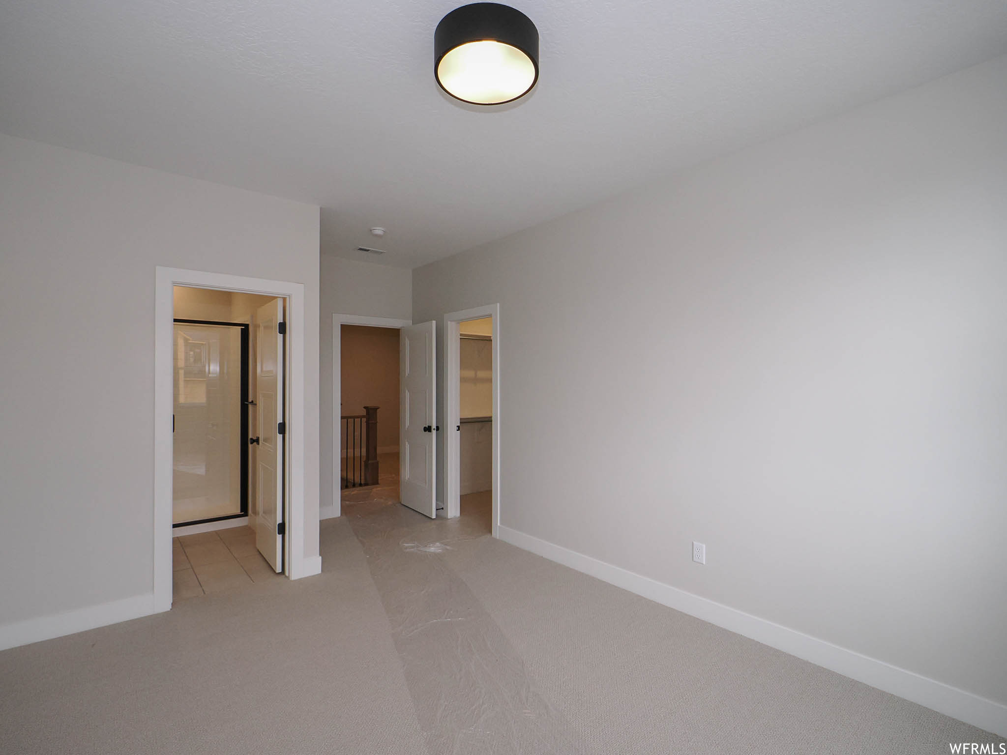 Empty room featuring light carpet