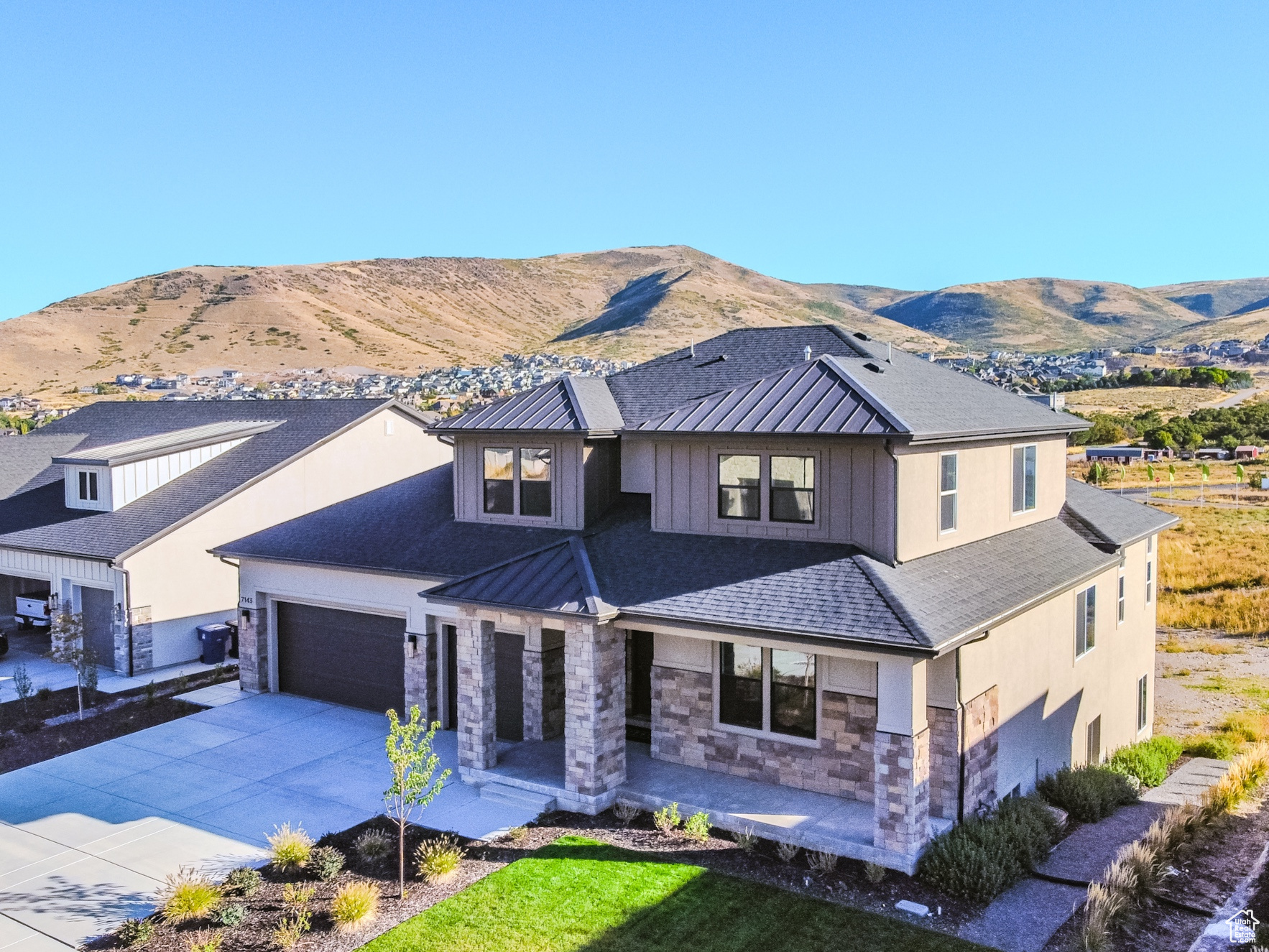 View of front facade featuring a mountain view, a garage, and a front lawn