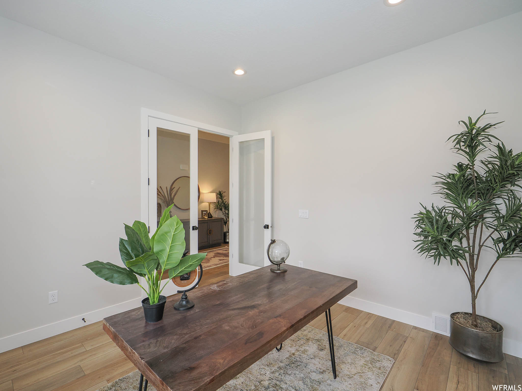 Hardwood floored home office with washing machine and dryer