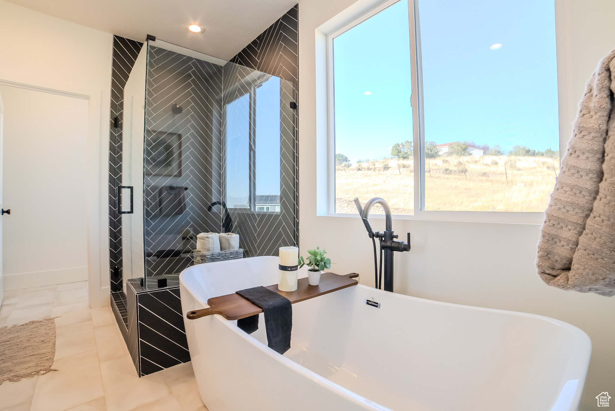 Bathroom with tile patterned flooring, independent shower and bath, a healthy amount of sunlight, and sink