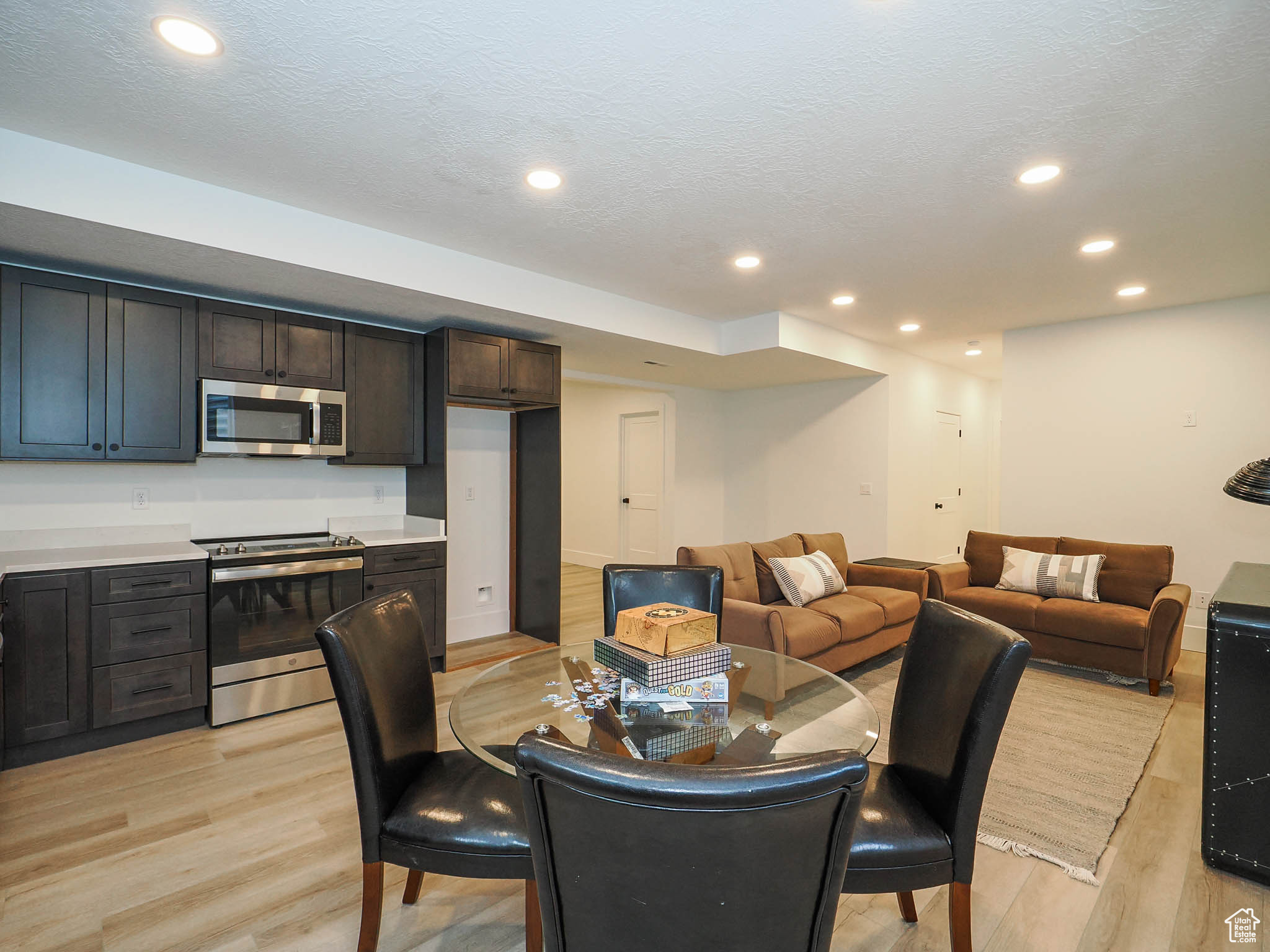 Dining area with a textured ceiling and light hardwood / wood-style floors