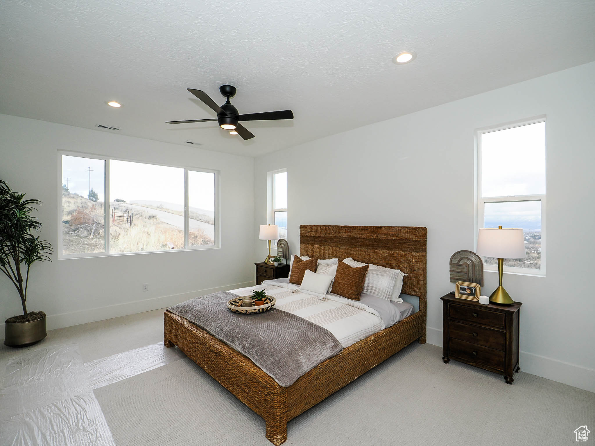 Bedroom featuring light carpet and ceiling fan