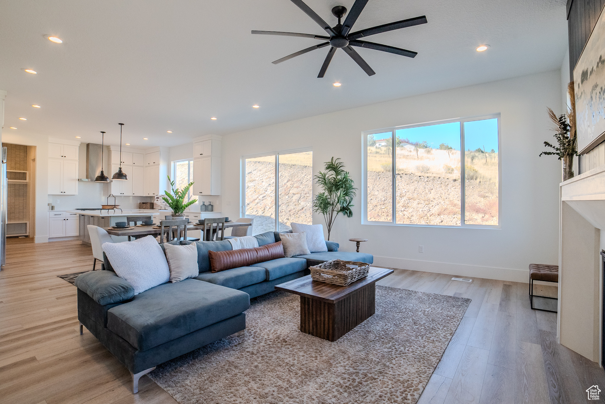 Living room with light hardwood / wood-style floors and ceiling fan