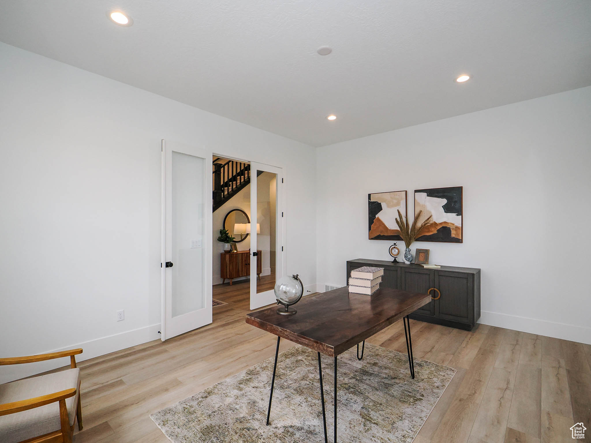 Office space with light hardwood / wood-style floors