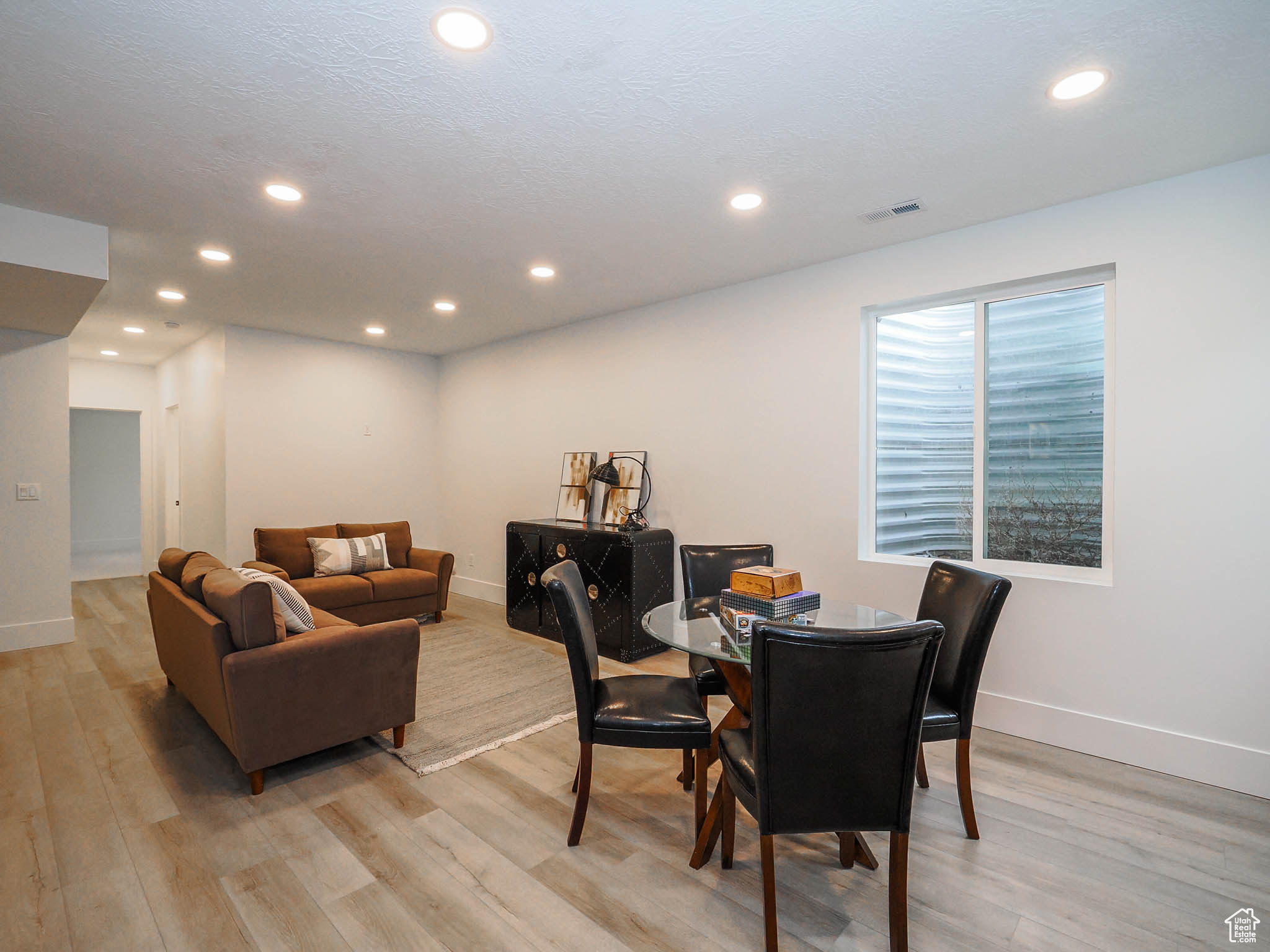 Dining space with a textured ceiling and light hardwood / wood-style floors