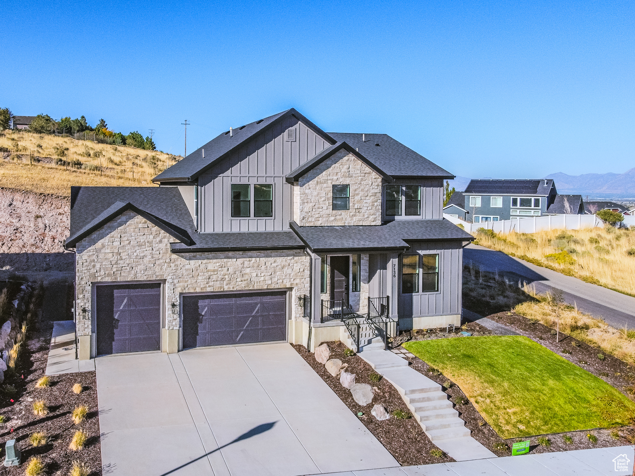 View of front facade with a mountain view, a front lawn, and a garage