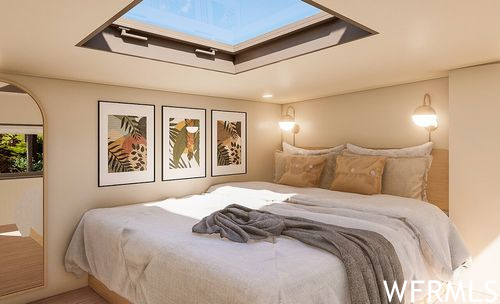 Bedroom featuring light parquet floors and a skylight