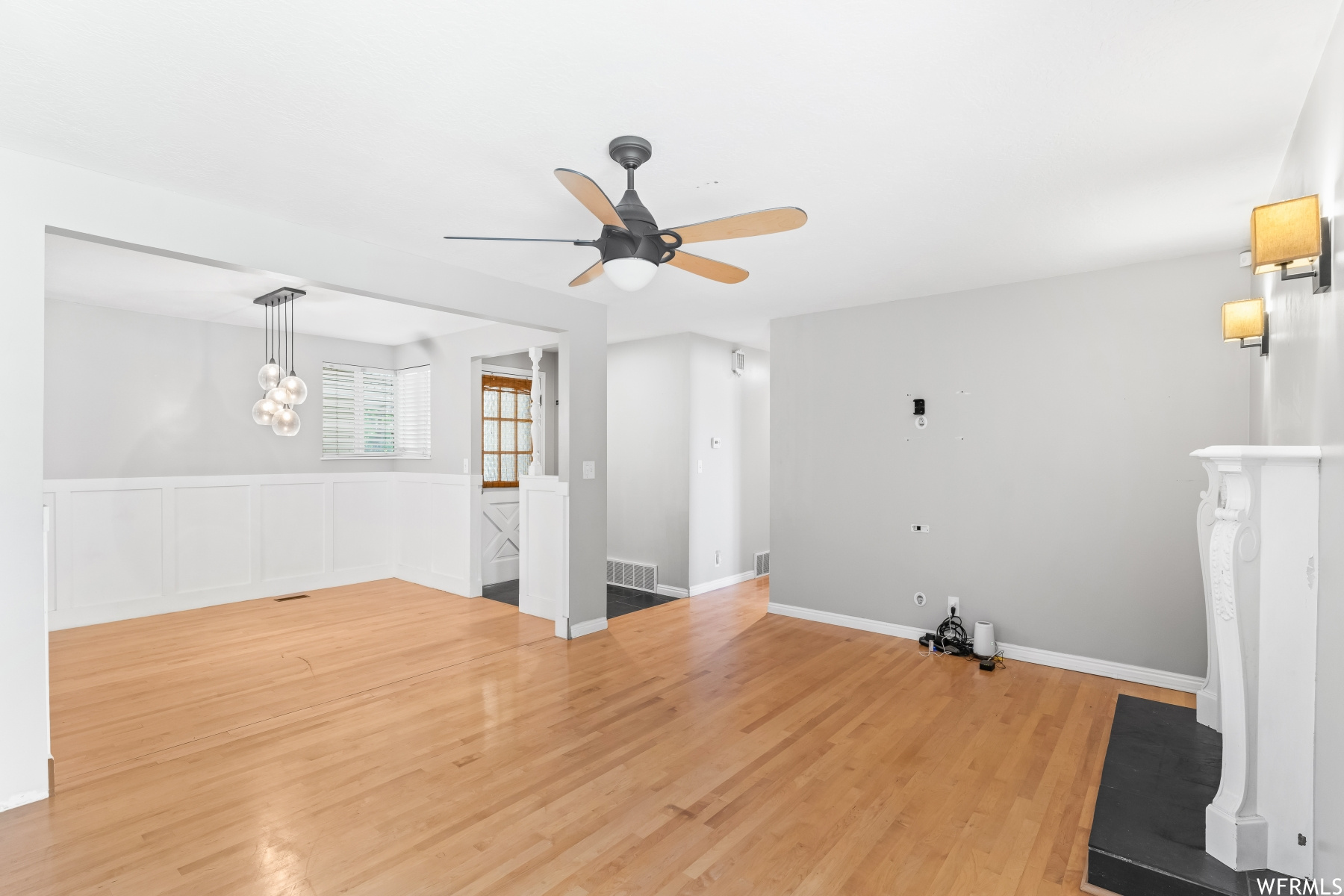 Hardwood flooring in living room featuring a ceiling fan