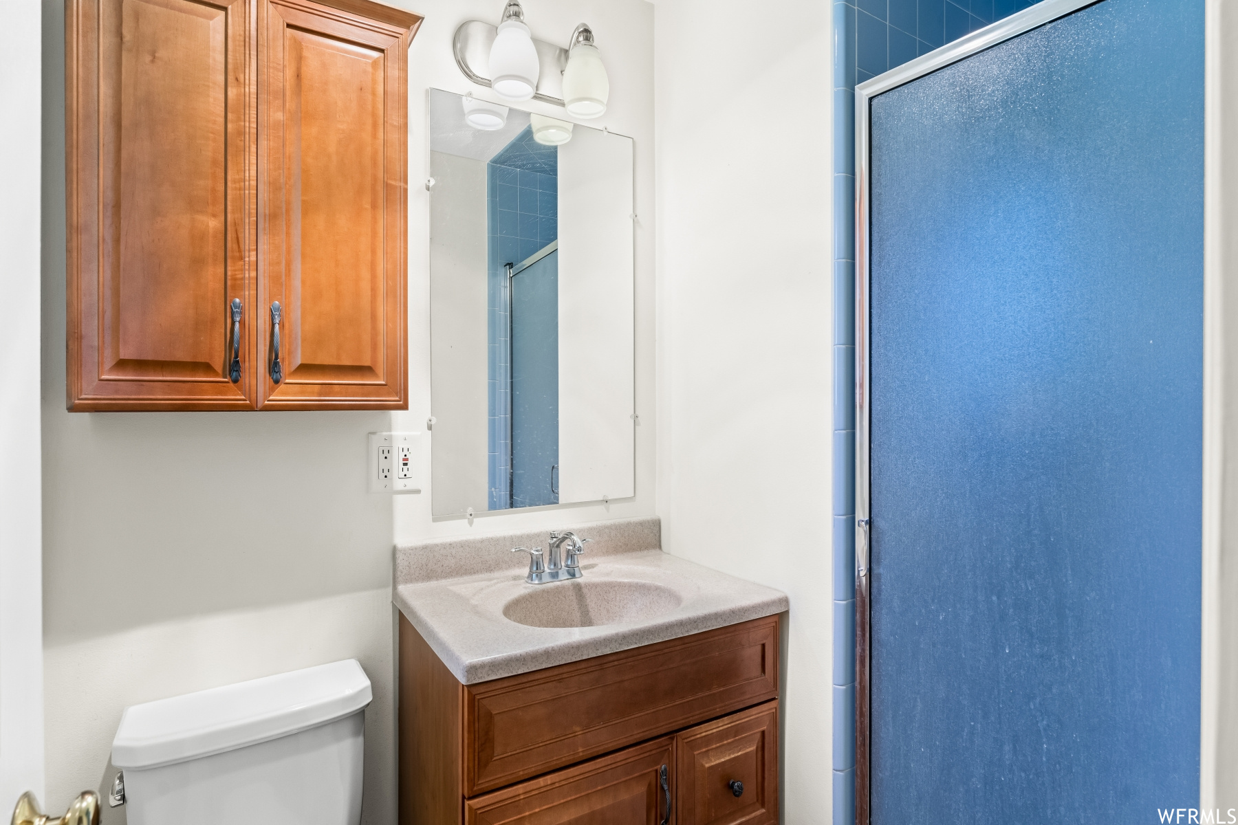 Bathroom with large vanity, mirror, and a shower with shower door