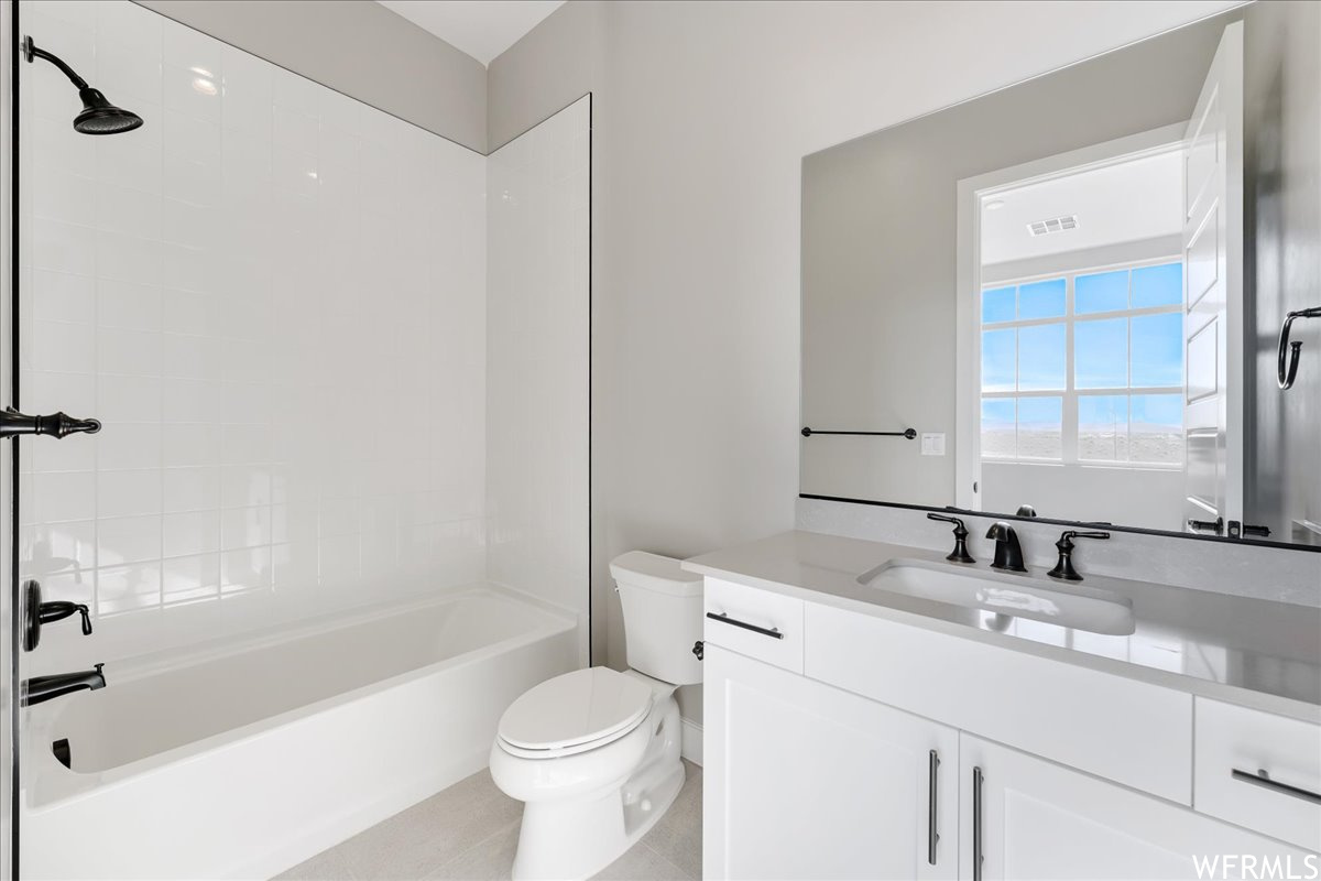 Full bathroom with large vanity, toilet, bathtub / shower combination, and tile flooring