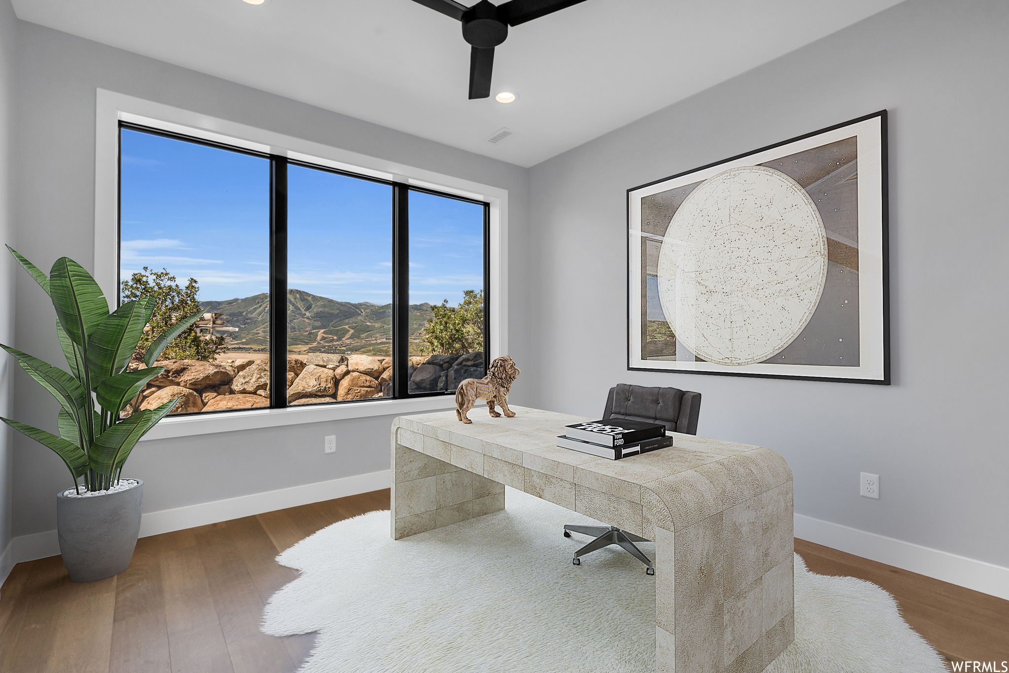 Office space featuring dark hardwood / wood-style floors and ceiling fan. STAGED