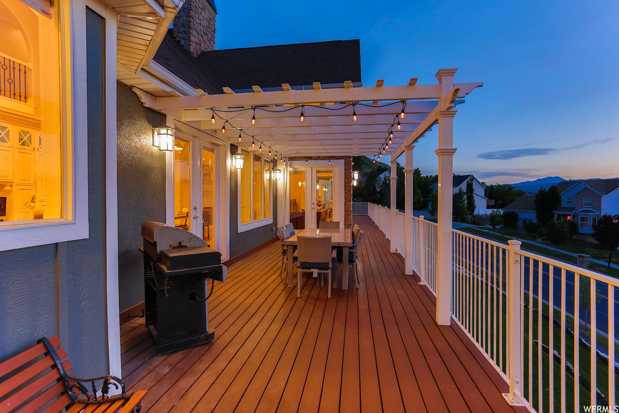 Deck at dusk featuring a pergola on the wrap around deck.
