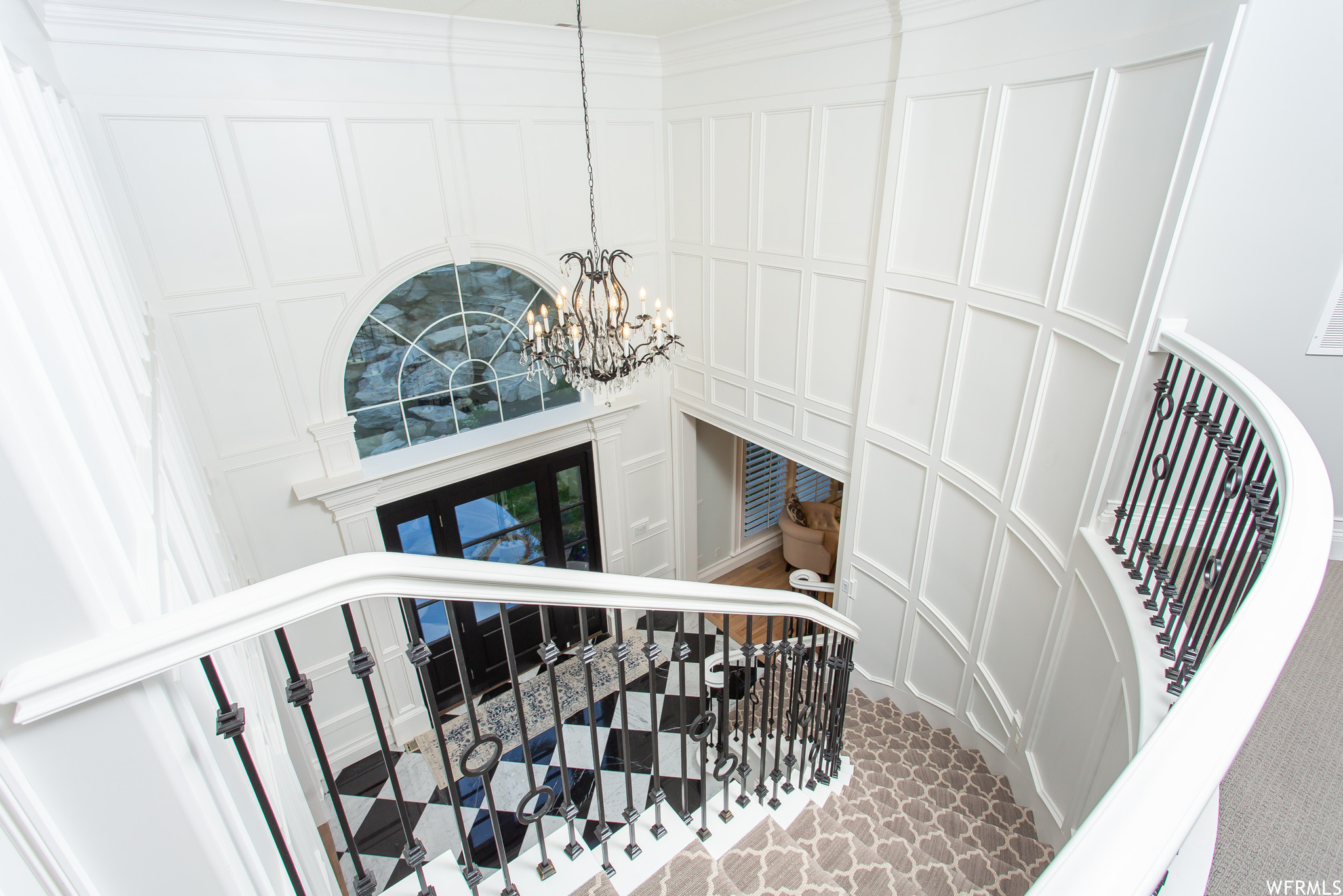 Stairway featuring a high ceiling and ornamental molding.