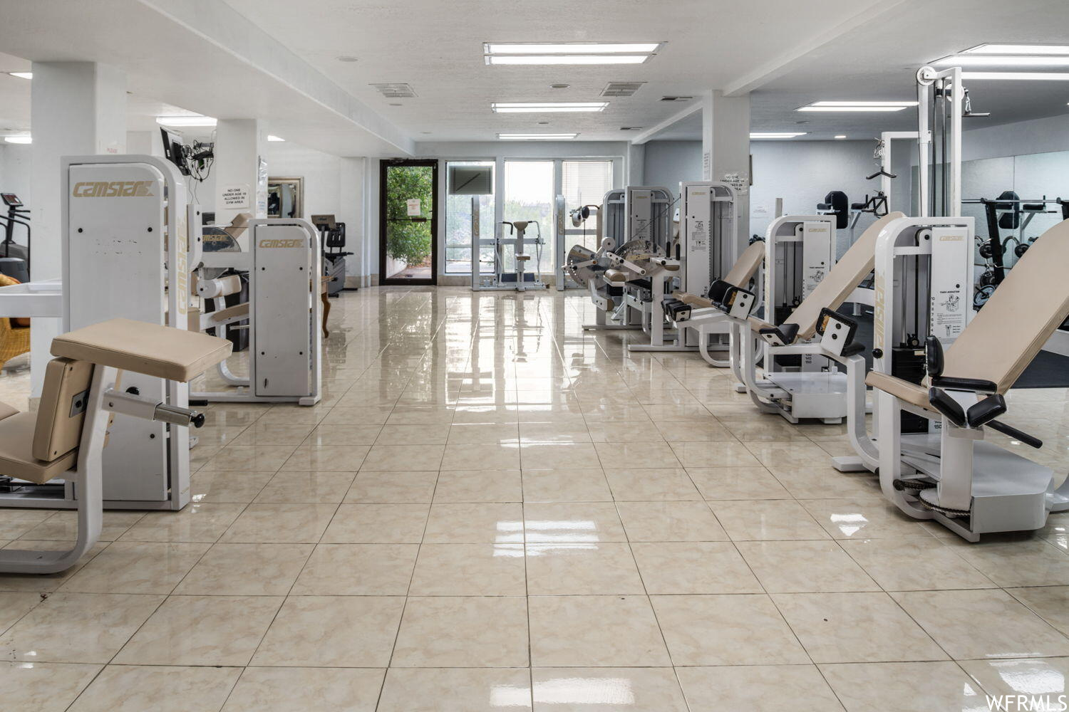 Exercise room featuring light tile floors