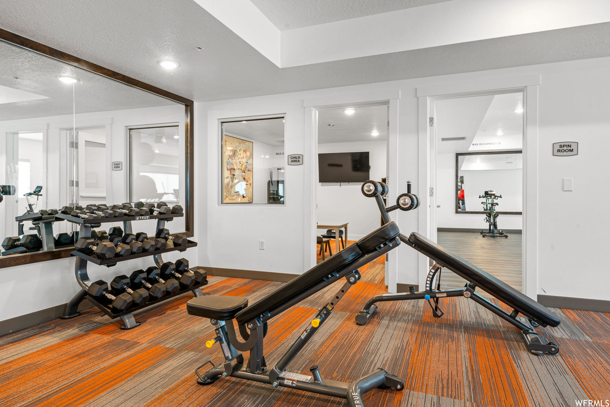 Workout area with a textured ceiling and light hardwood floors