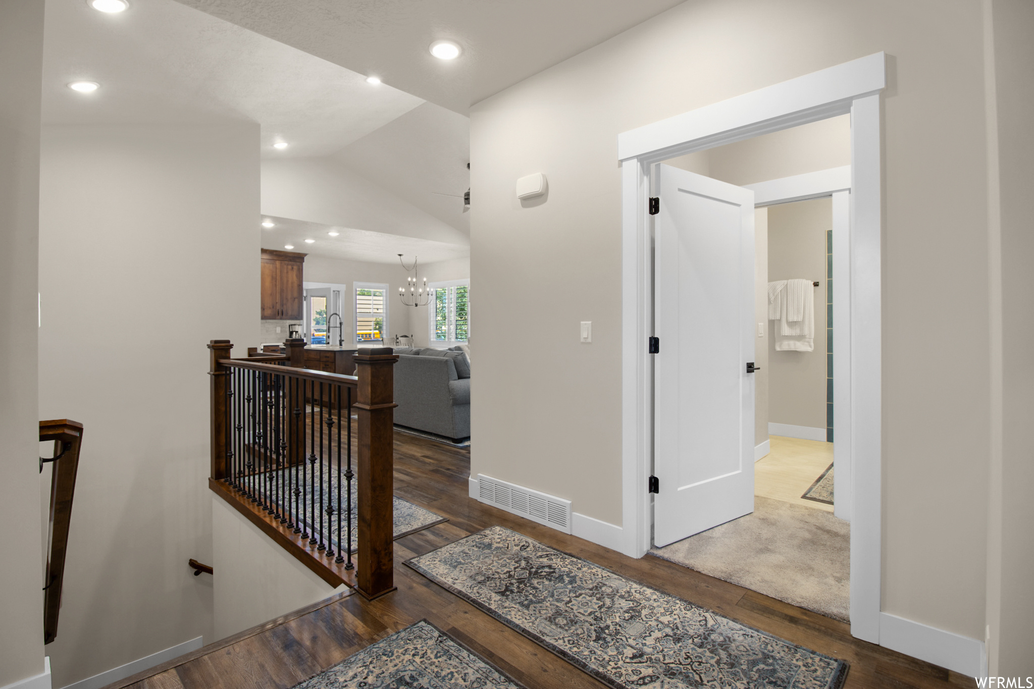 Corridor featuring light carpet and lofted ceiling