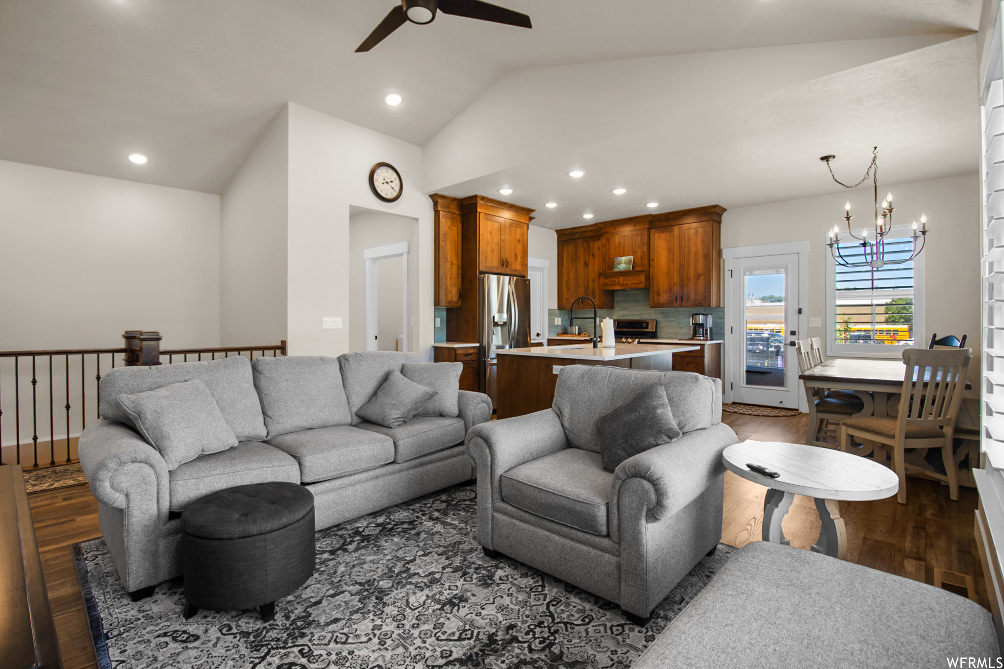 Hardwood floored living room featuring vaulted ceiling