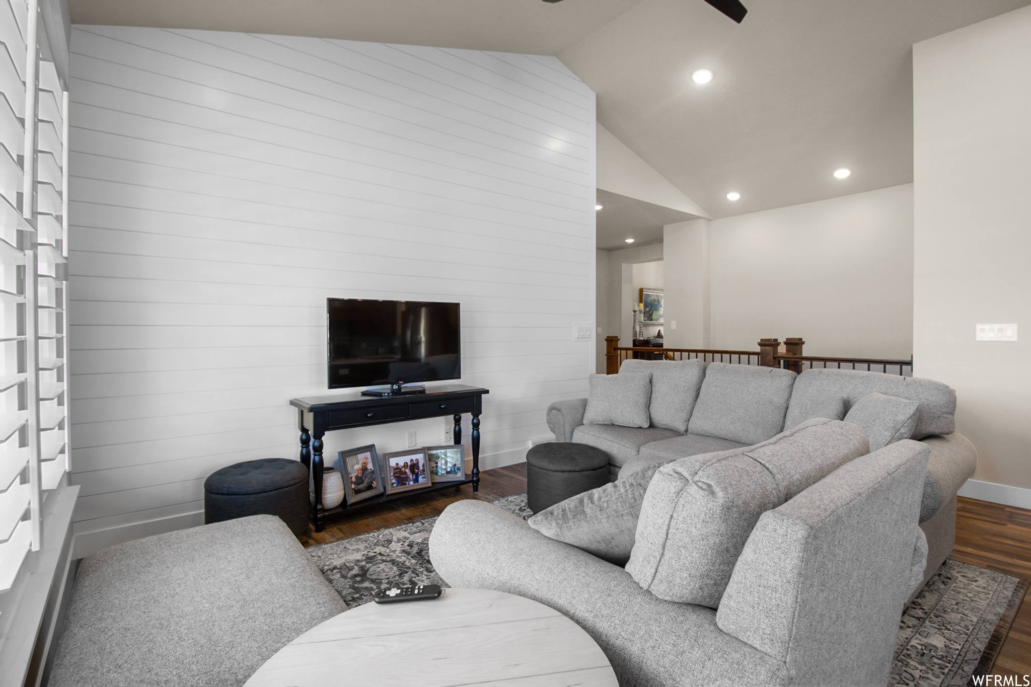 Hardwood floored living room with vaulted ceiling and a high ceiling