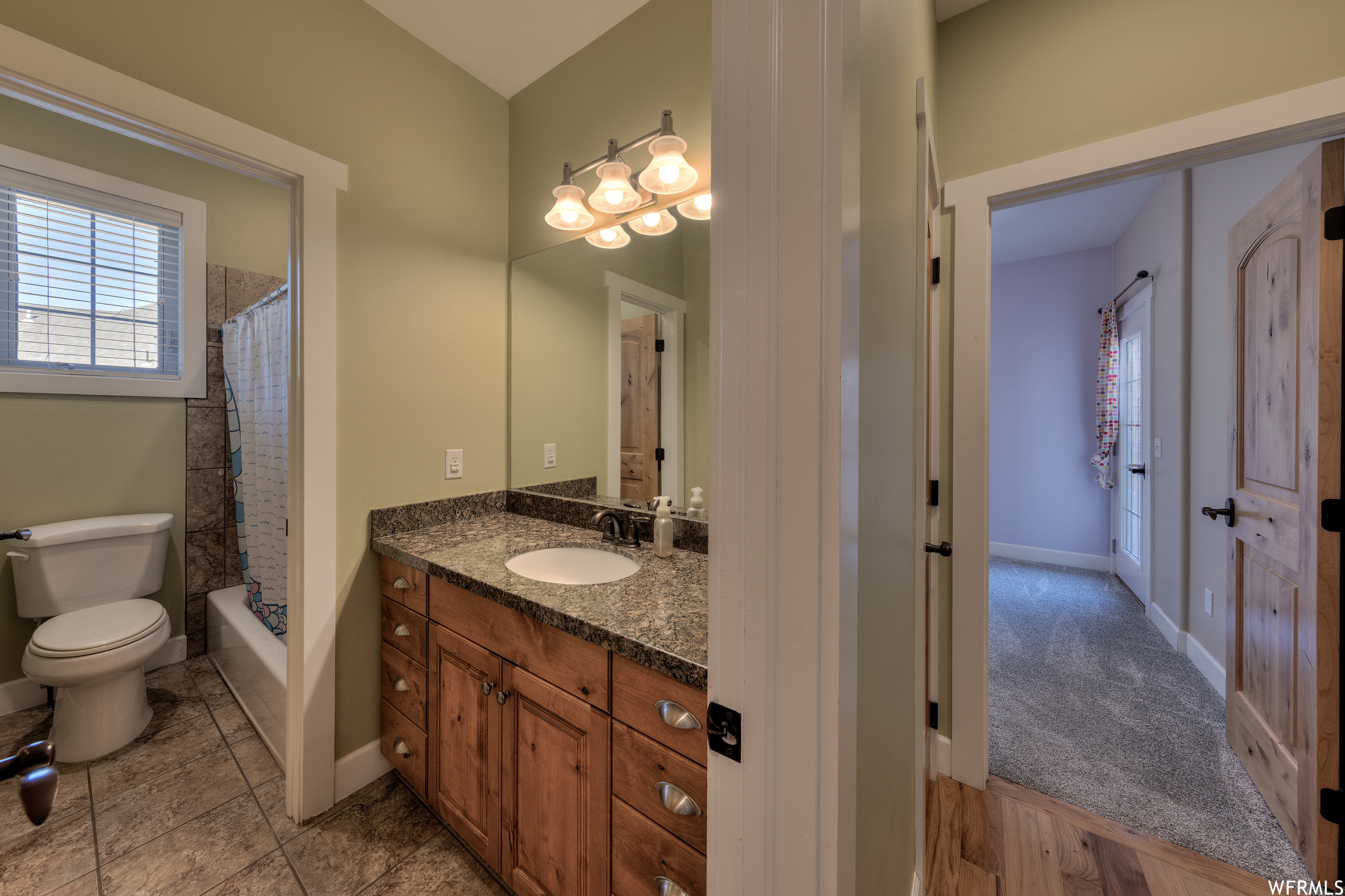 Full bathroom featuring tile floors, shower / tub combo with curtain, vanity, and mirror