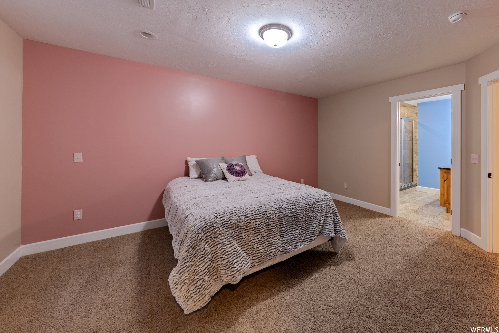 Bedroom featuring a textured ceiling and dark carpet