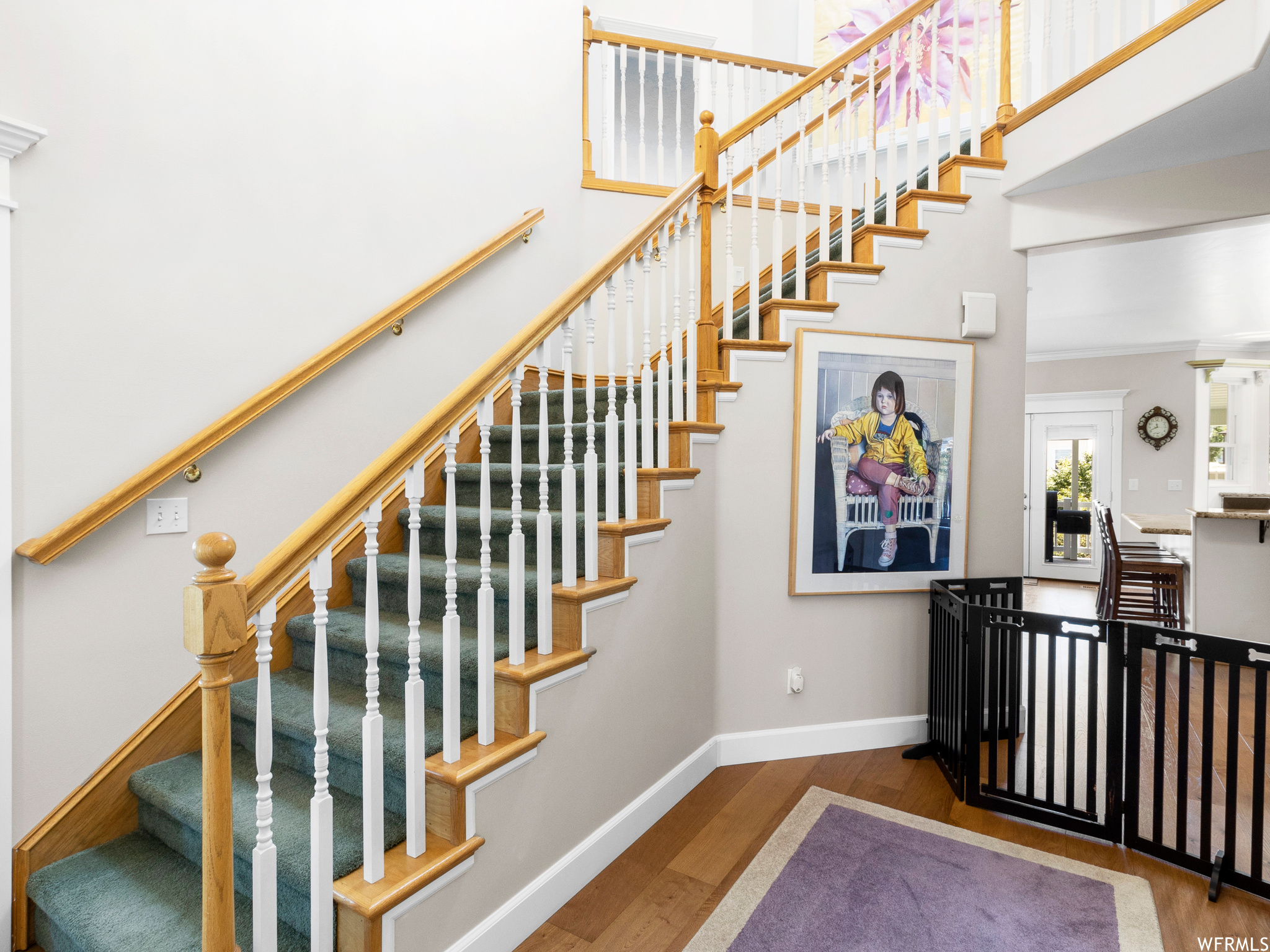 Staircase with a high ceiling and light hardwood flooring