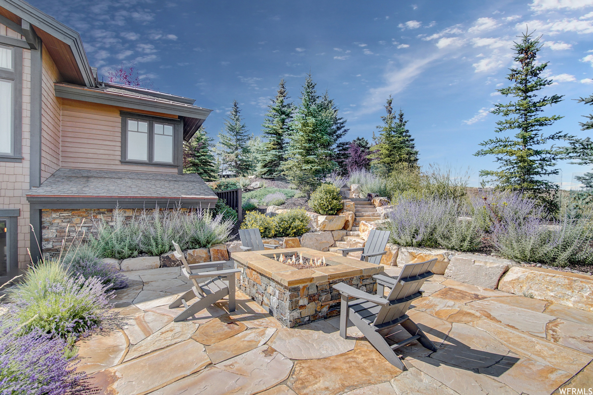 Flagstone patio / terrace with a custom stone firepit