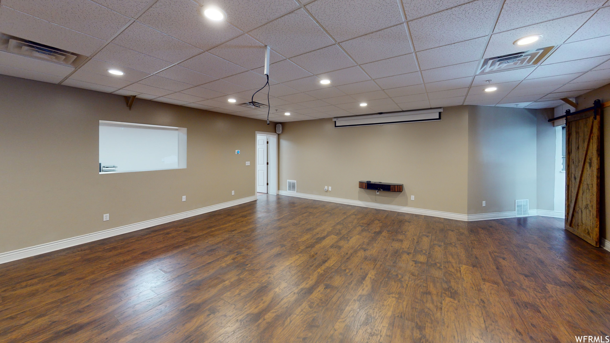 Hardwood floored spare room with a drop ceiling